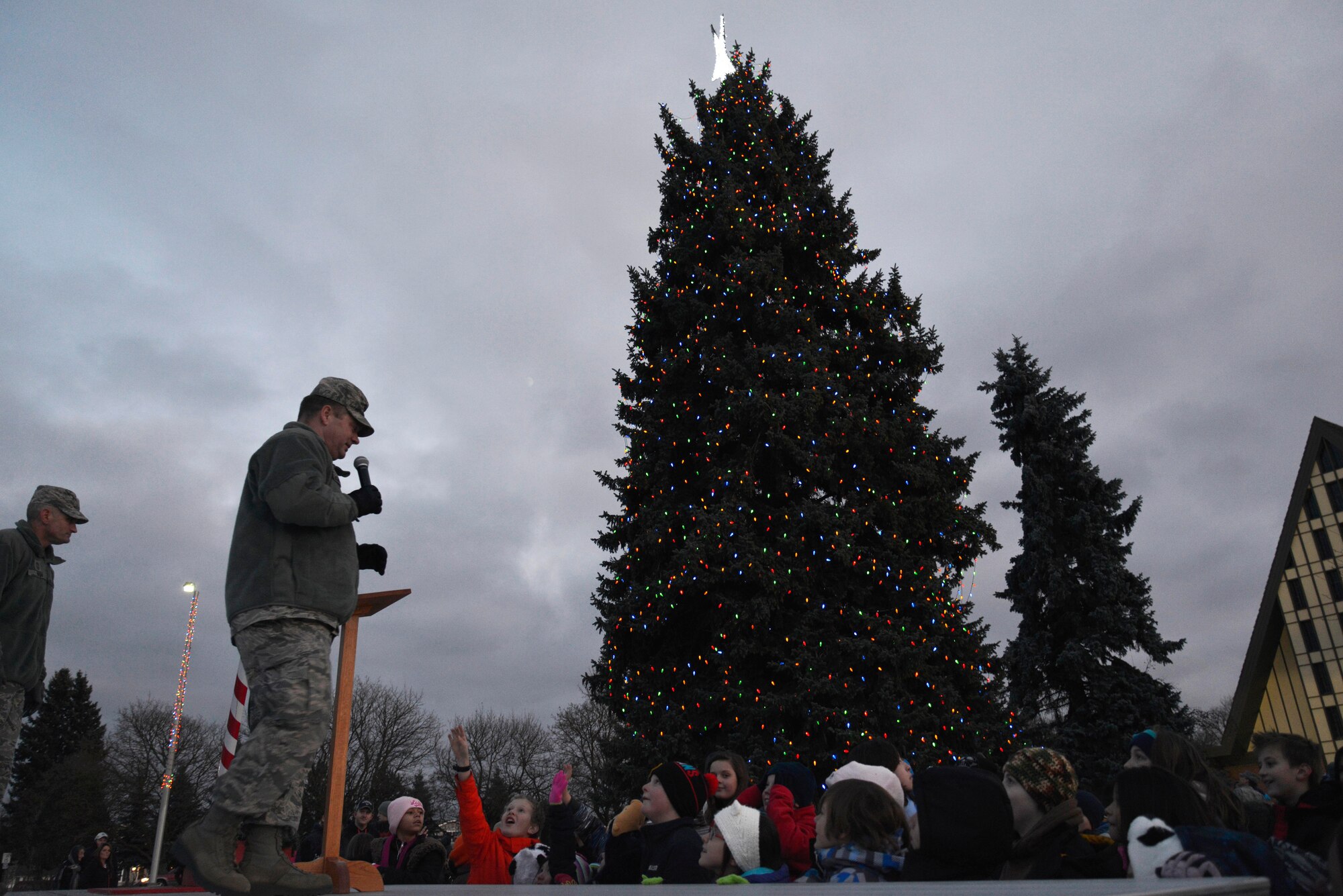 Col. Brian McDaniel, 92nd Air Refueling Wing commander, converses with kids during the annual tree lighting ceremony Dec. 1, 2014, at Fairchild Air Force Base, Wash. The ceremony included a singing performance from Michael Anderson Elementary School students and a visit from Santa. (U.S. Air Force photo/Airman 1st Class Janelle Patiño)