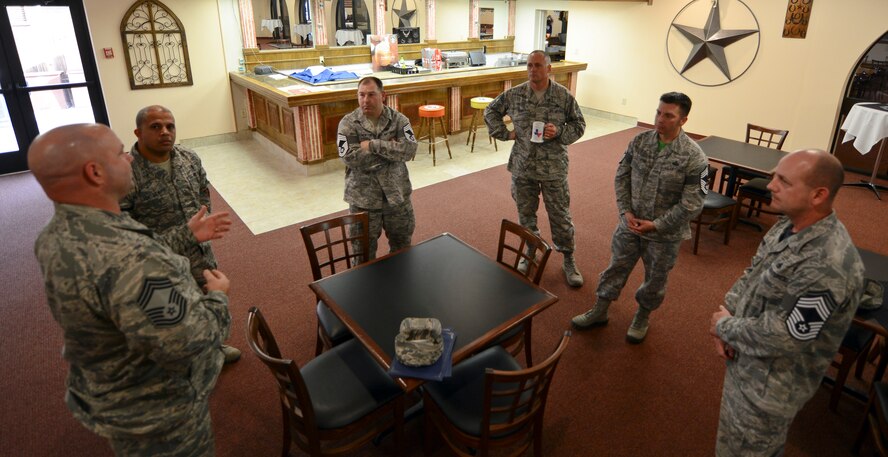 U.S. Air Force Chief Master Sgt. Aaron Bennett, 7th Mission Support Group superintendent, speaks to four chief master sergeant selects Nov. 21, 2014, at Dyess Air Force Base, Texas. Six Dyess Airmen were selected amongst 2,525 eligible senior master sergeants Air Force-wide. (U.S. Air Force photo by Airman 1st Class Kedesha Pennant/Released)
