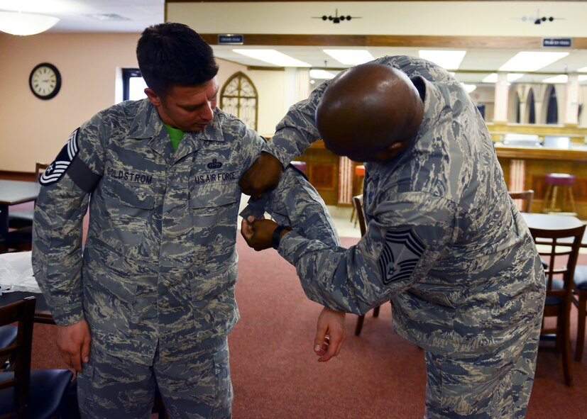 U.S. Air Force Chief Master Sgt. Joel Brown, 7th Logistics Readiness Squadron fuels manager, puts chief master sergeant stripes on Senior Master Sgt. Antonio Goldstrom, 7th Communications Squadron superintendent, Nov. 21, 2014, at Dyess Air Force Base, Texas. By receiving chief master sergeant, Goldstrom joins the ranks of the top one percent of the enlisted force. (U.S. Air Force photo by Airman 1st Class Kedesha Pennant/Released)