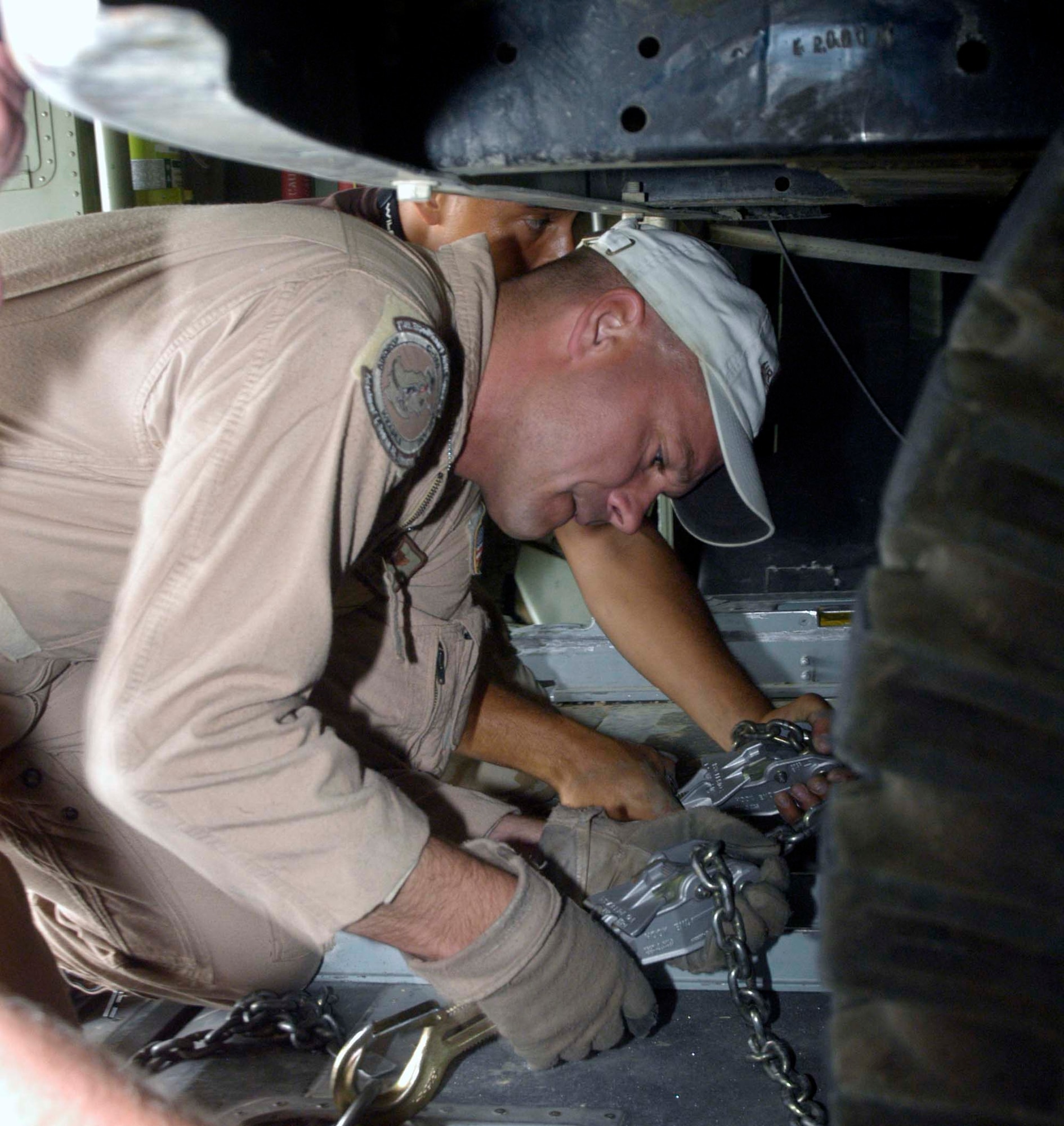 Master Sgt. Jeff Springsteen secures a four-wheel drive vehicle in the back of a C-130 Hercules cargo plane in Kabul, Afghanistan, Aug. 10, 2006. Springsteen is a C-130 loadmaster from the Delaware Air National Guard's 142nd Airlift Squadron, currently deployed to the 774th Expeditionary Airlift Squadron at Bagram Airfield, Afghanistan. C-130s provide the bulk of the airlift and airdrop to re-supply U.S. and Coalition forces throughout Afghanistan. The 774th EAS is manned by Air Guardsmen from Delaware, Alaska, Tennessee, Texas, Nevada, Wyoming, Arkansas and Puerto Rico. (U.S. Air Force photo by Maj. David Kurle)