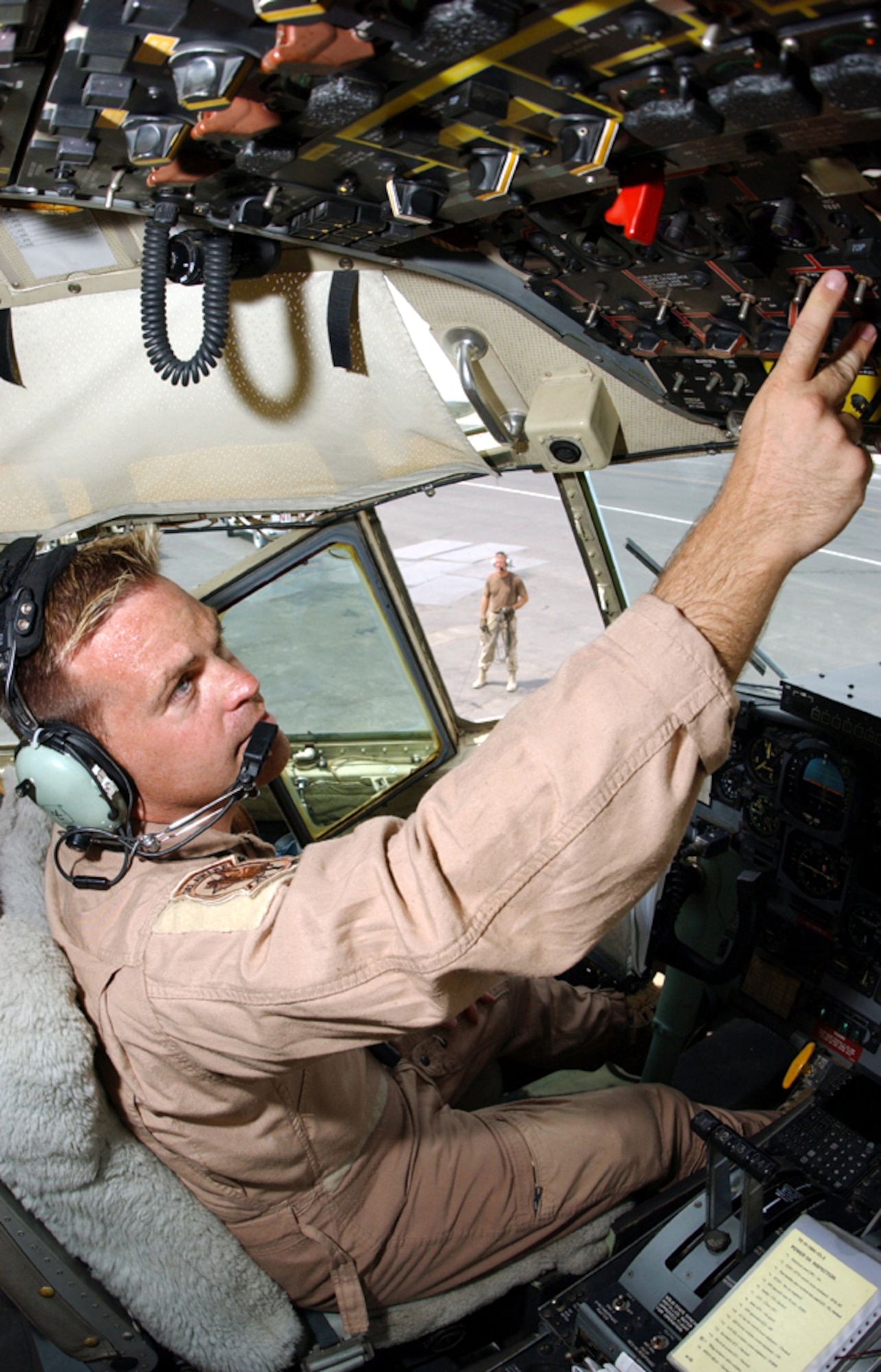 Master Sgts. Tom Rutt (foreground) and Scott Nybakken work in unison at a forward-deployed location in Southwest Asia ensuring a C-130 Hercules is ready for an airlift mission to Iraq on July 8, 2003. Rutt, a flight engineer, and Nybakken, a crew chief, are both assigned to the Delaware Air National Guard’s 166th Airlift Wing. (U.S. Air Force photo by Master Sgt. Terry L. Blevins)