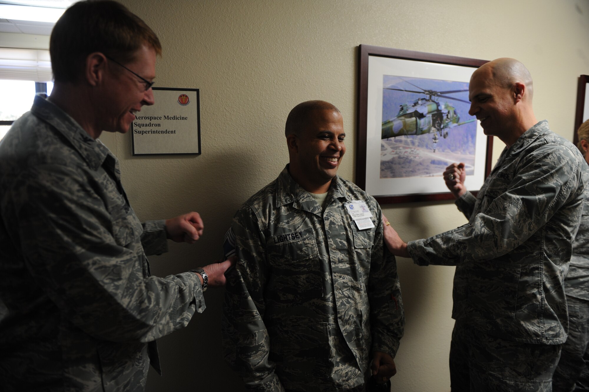 U.S. Air Force Senior Master Sgt. Randy Lightsey, 7th Aerospace Medicine Squadron superintendent, has his new stripes pinned on by Col. Michael Bob Starr, 7th Bomb Wing commander, and Col. Robert Bogart, 7th Medical Group commander, Nov. 11, 2014, at Dyess Air Force Base, Texas. Lightsey was among only 400 senior master sergeants in the Air Force selected for promotion to chief master sergeant. (U.S. Air Force photo by Airman 1st Class Alexander Guerrero/Released)