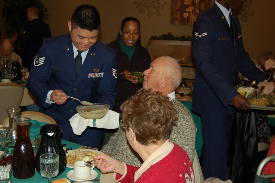 Staff Sgt. John Carlo Condol, 5th Force Support Squardon installation personnel readiness journeyman, serves food to guests at the Day of Love event on Minot Air Force Base, N.D., Nov. 27, 2014. Nearly 100 military and civilian members volunteered at the event, which has been going on since 1969. Senior citizens from across Minot, N.D., and surrounding communities travel to the base to eat a Thanksgiving meal and enjoy the company of Team Minot’s family. (Courtesy photo) 
 
