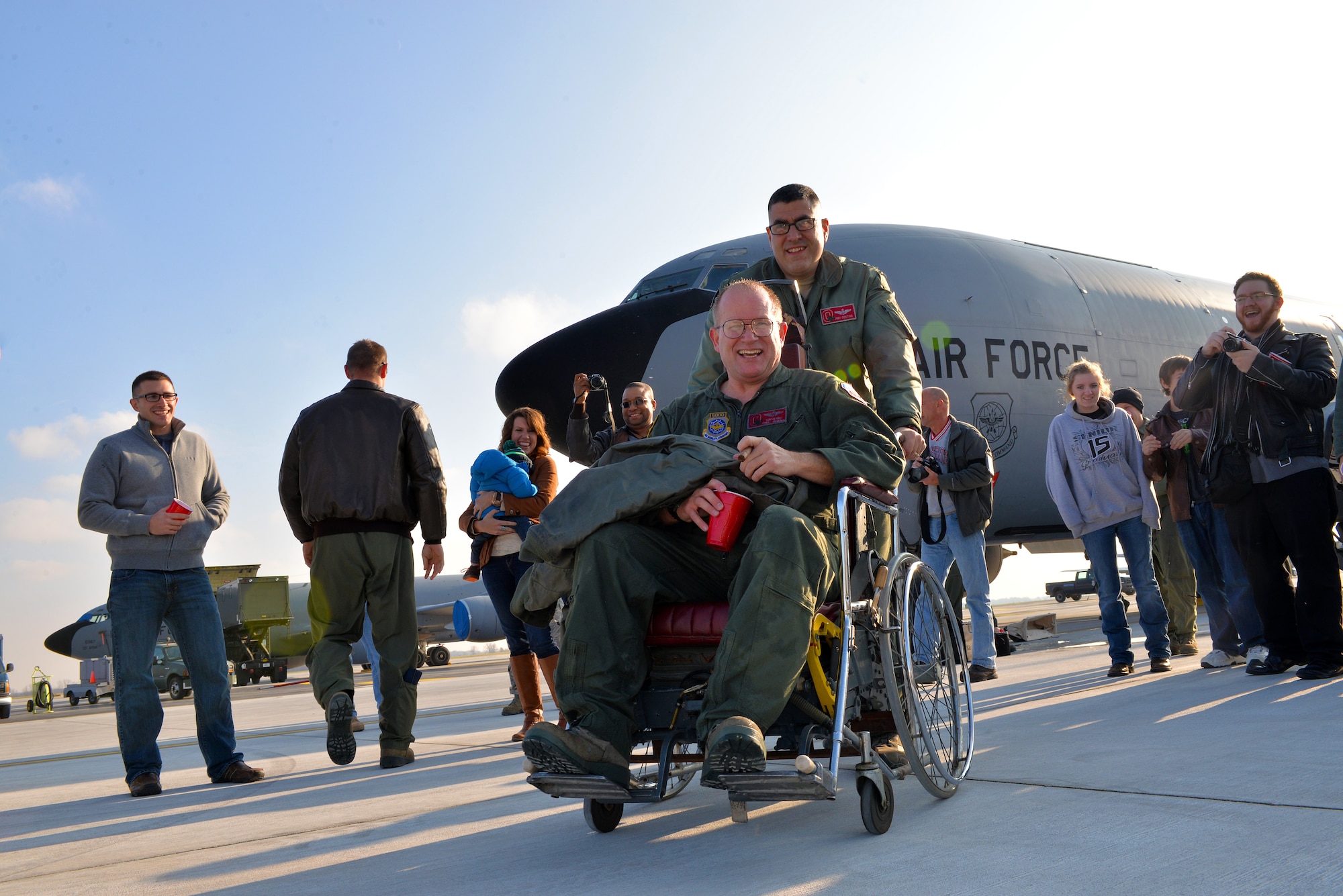 Chief Master Sgt. Tom Guard, a boom operator in the 121st Air Refueling Wing, gets a ride in a wheelchair from Lt. Col. Joe Contino Nov. 26, 2014, at Rickenbacker Air National Guard Base, Ohio. Guard had just completed his final flight after 41 years of service. (U.S. Air National Guard photo by Master Sgt. Ralph Branson/Released)