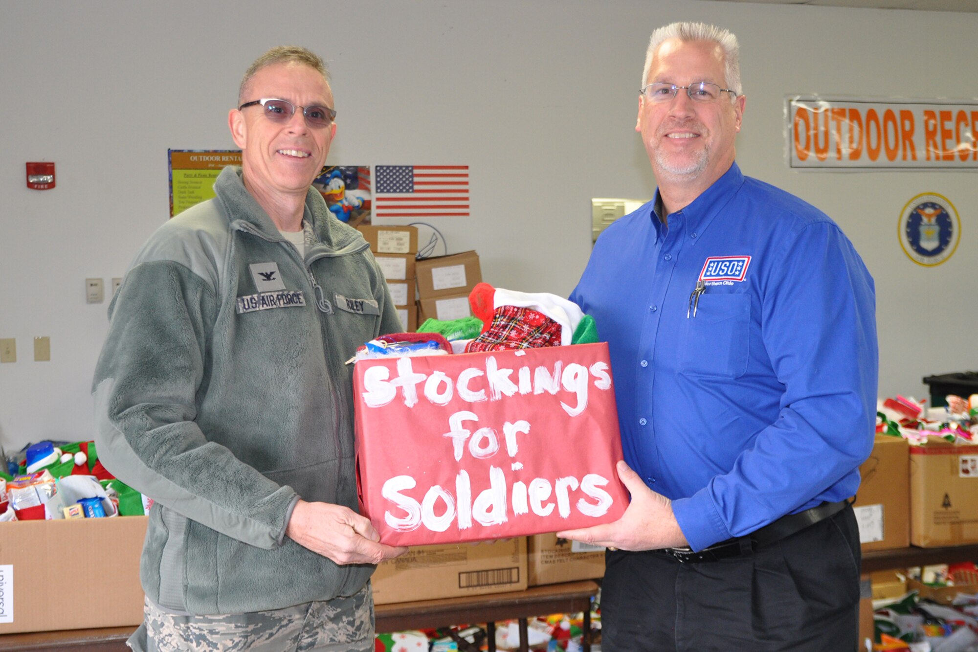 YOUNGSTOWN AIR RESERVE STATION, Ohio – Air Force Reserve Col. Kevin Riley, commander of the 910th Airlift Wing’s 910th Mission Support Group based here, accepts a package of yuletide cheer from Mr. Bruce Billie, Trumbull and Mahoning Counties Coordinator for the USO of Northern Ohio at the YARS Fitness Center here, Nov. 26, 2014. The carefully-prepared box represents more than 950 stockings brimming with goodies, holiday greeting cards, food stuffs and more, courtesy of the USO of Northern Ohio and the citizenry of the Cleveland suburb of Willoughby Hills, Ohio, that arrived at YARS to be passed out later to the Air Force, Marine and Navy Reservists assigned here at upcoming holiday festivities. The mission of the USO of Northern Ohio is to lift the spirits of our local troops and their families by enhancing the quality of life with recreational programs and services that boost the morale of the U.S. Armed Forces personnel serving in and from the 29 northernmost counties of the great State of Ohio. The USO of Northern Ohio will also try to cultivate cooperative relationships between U.S. military communities and involved or supporting civilian communities. For more information about the USO of Northern Ohio, visit their website at: http://usonorthernohio.org/ U.S. Air Force photo by Master Sgt. Bob Barko Jr.
