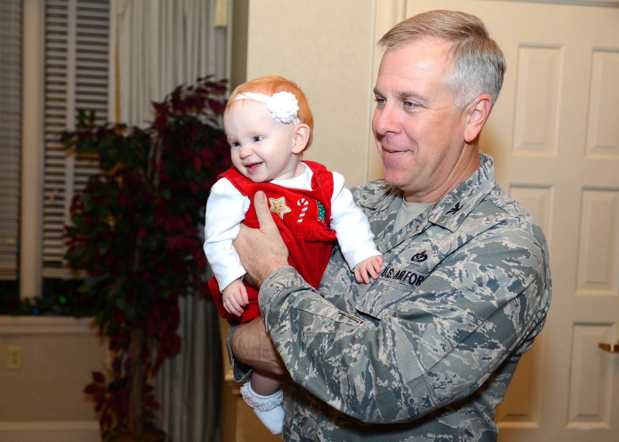 U.S. Air Force Col. John J. Allen Jr. holds 10-month-old Anna Elizabeth McDonald, daughter of Chaplain (Capt.) Michael McDonald, 1st Fighter Wing chaplain, after the holiday tree-lighting ceremony at Langley Air Force Base, Va., Dec. 1, 2014. After the ceremony, attendees were invited to the Langley Officer’s Club for free snacks and a holiday social with Santa Clause. (U.S. Air Force photo by Airman 1st Class Devin Scott Michaels/Released)