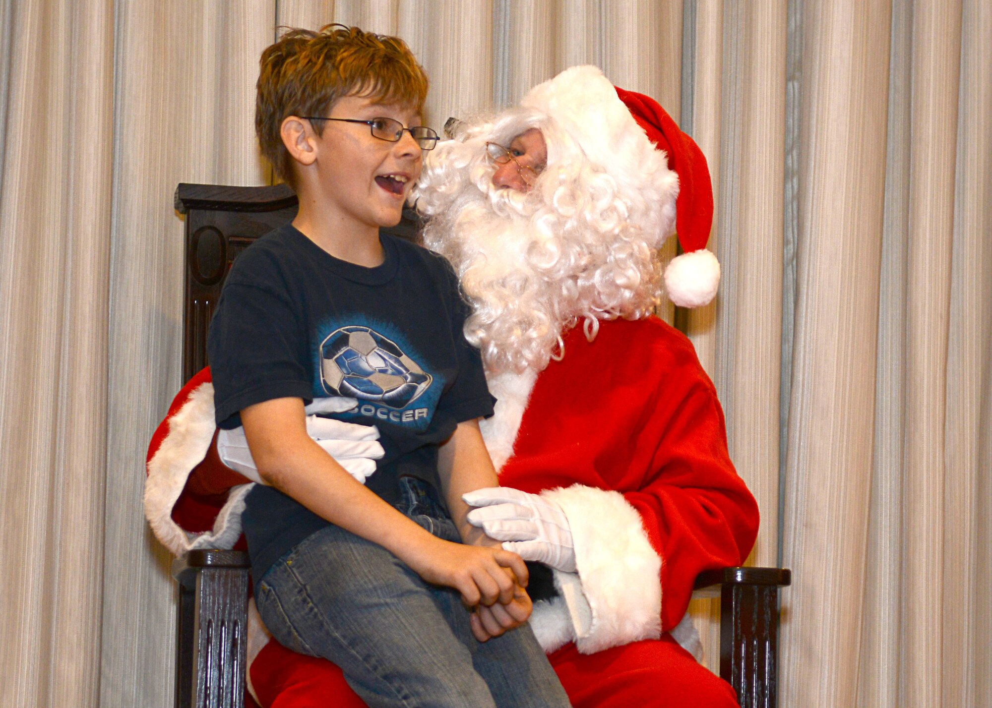 Austin Anhalt, son of U.S. Air Force Capt. Melissa Anhalt, 633rd Medical Operations Squadron emergency room nurse, asks Santa Clause for a toy after the holiday tree-lighting ceremony at Langley Air Force Base, Va., Dec. 1, 2014. Santa Clause visited the Langley Officer’s Club after the ceremony and asked children what they wanted this holiday season. (U.S. Air Force photo by Airman 1st Class Devin Scott Michaels/Released)