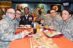 U.S. Army Command Sgt. Maj. Cynthia B. Howard, Transportation Corps Regimental command sergeant major, enjoys a Thanksgiving meal with Soldiers from the 7th Transportation Brigade (Expeditionary) at the Resolute Dining Facility on Fort Eustis, Nov. 26, 2014. Senior leadership served civilian employees, Soldiers and their families the meal while wearing their dress uniform, which is a longstanding Army tradition. (U.S. Army photo by Spc. Marian Alleva/Released)
