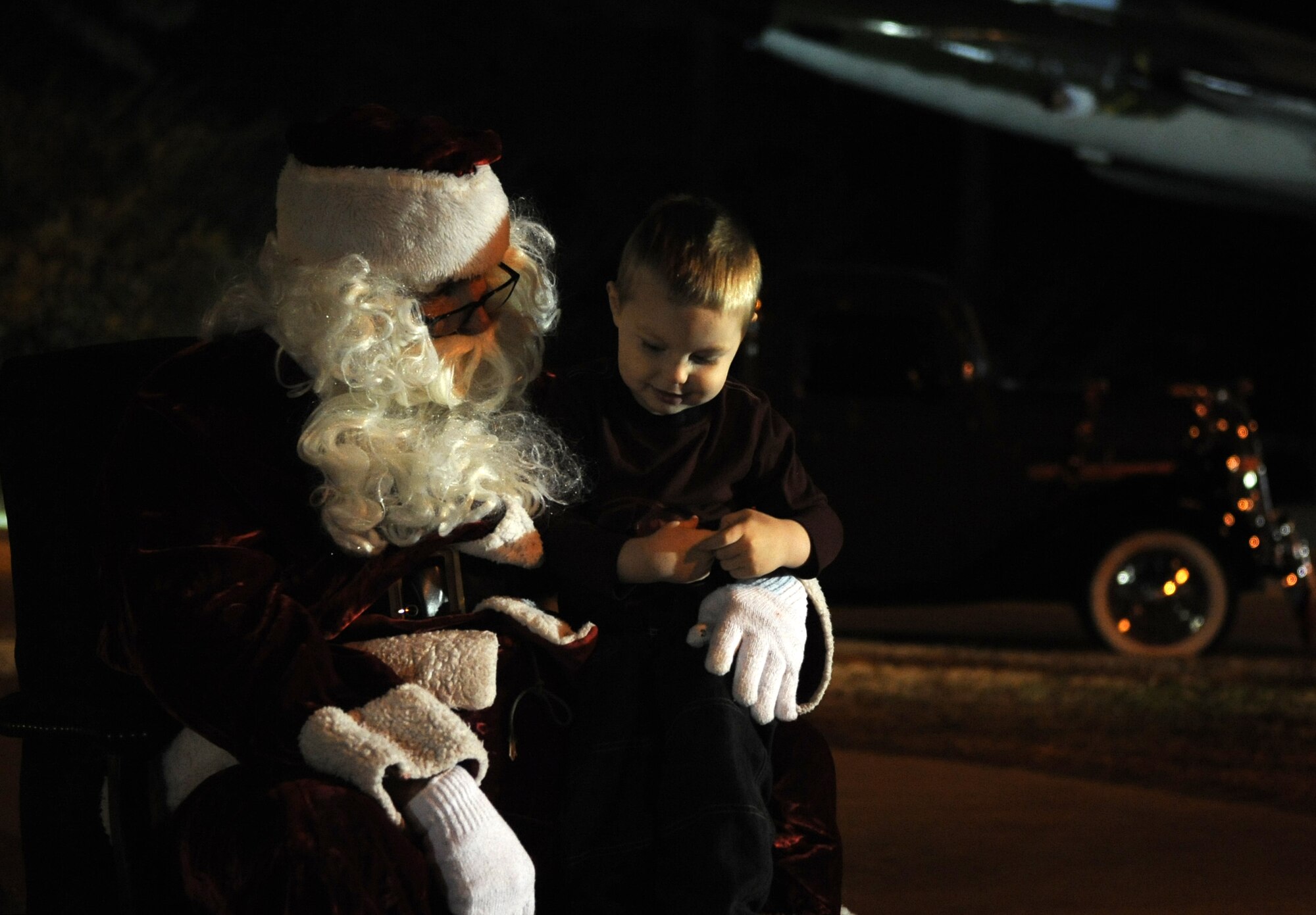 A younger member of Team Seymour tells Santa Claus his holiday wish list during the base tree lighting ceremony at Seymour Johnson Air Force Base, North Carolina, Dec. 1, 2014. Interacting with Santa and his elves was one of many holiday-themed activities Airmen and their families enjoyed at the event. (U.S. Air Force photo/Senior Airman Ashley J. Thum)