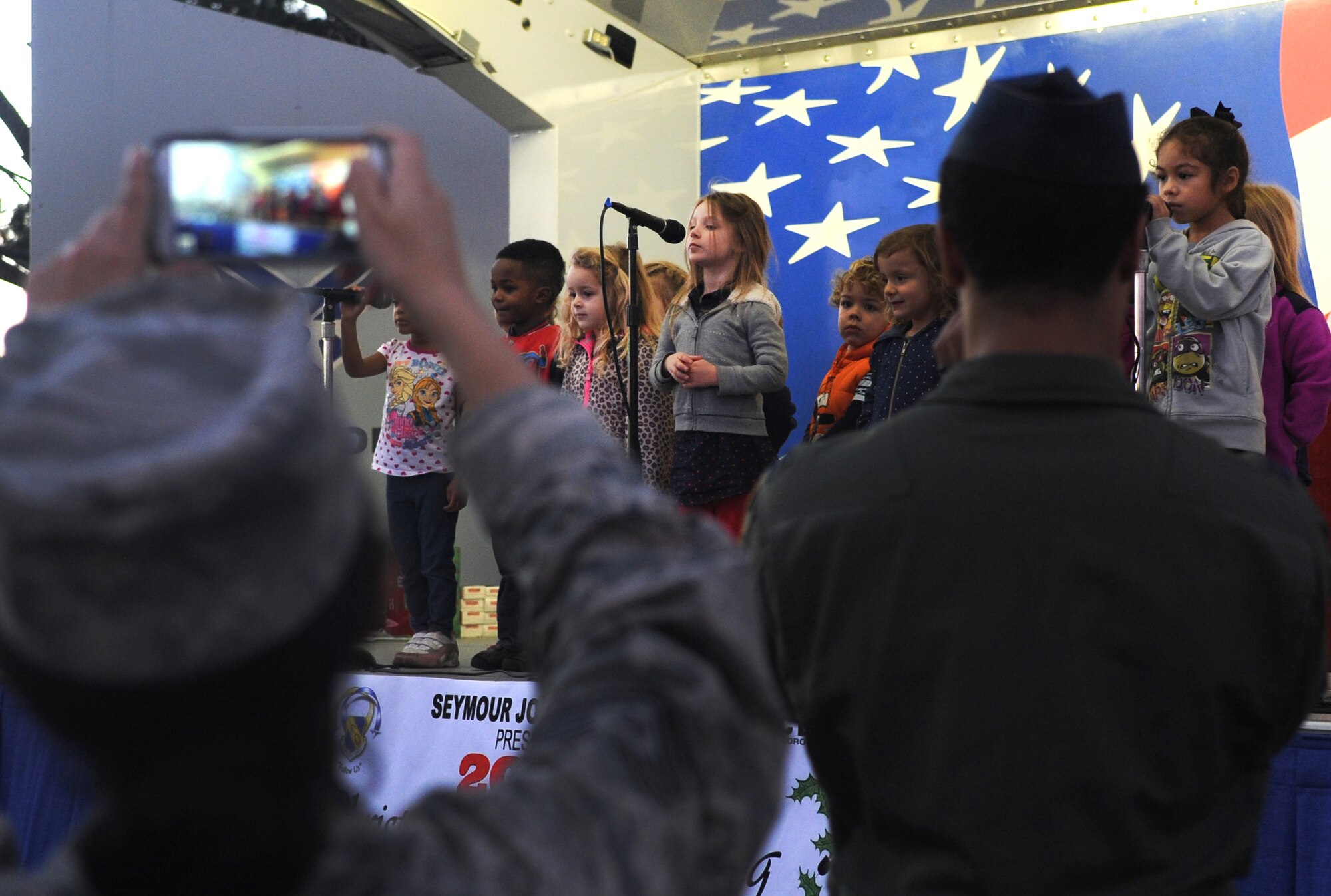 Children from the Child Development Center sing to their adoring fans during the base tree lighting ceremony at Seymour Johnson Air Force Base, North Carolina, Dec. 1, 2014. Different age groups from the CDC and the Youth Center delighted the audience with their rendition of holiday carols, including “What Does a Santa Say?” and “Rockin’ Around the Christmas Tree.” (U.S. Air Force photo/Senior Airman Ashley J. Thum)