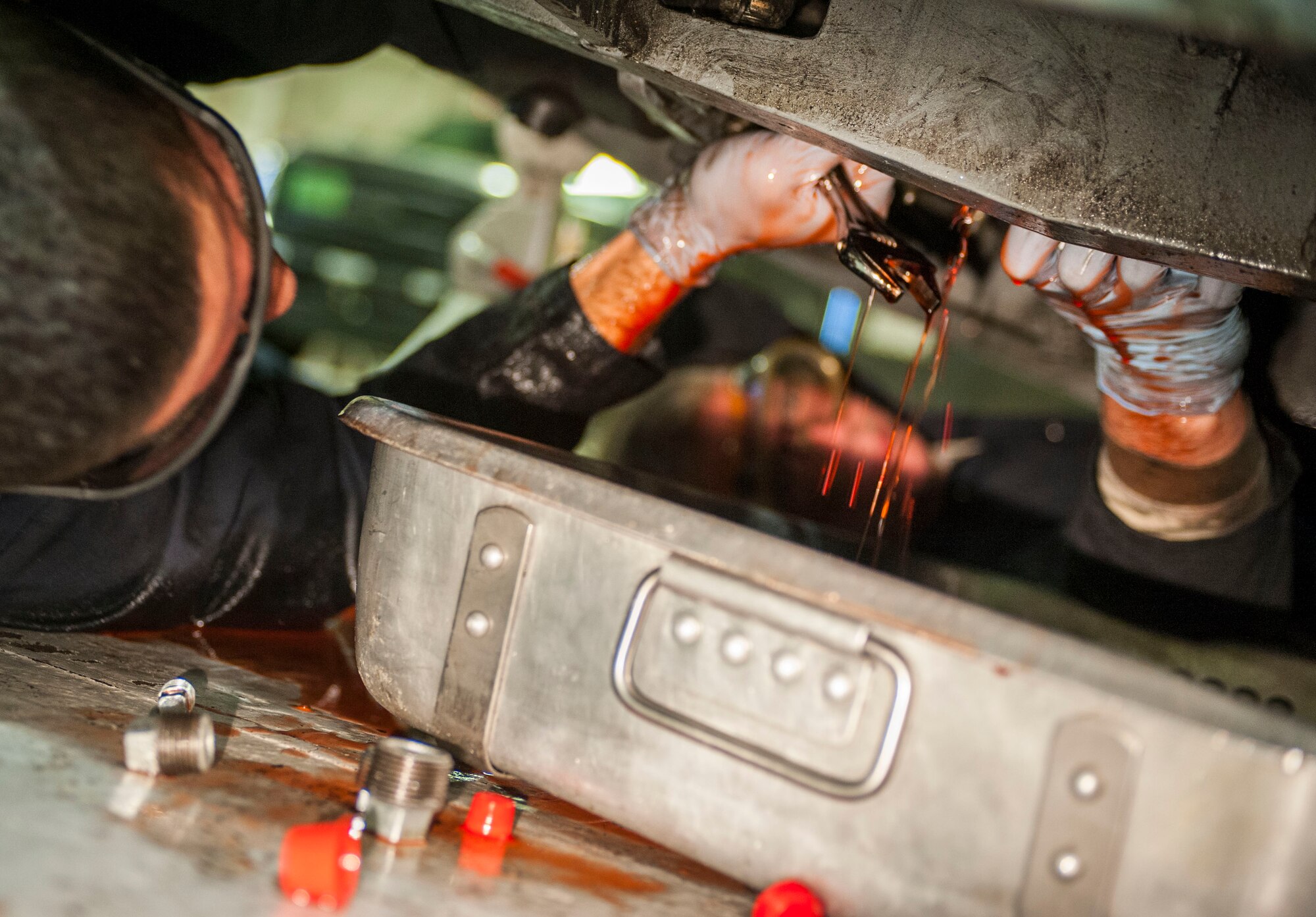 Senior Airman Michael Maldonada, 5th Maintenance Squadron air ground equipment journeyman, and Airman 1st Class Nathan Austin, 5th MXS AGE apprentice, work together to repair a brake line on Minot Air Force Base, N.D., Nov. 25, 2014. Maldonada and Austin adjusted the brake pedal and repaired the brake line after isolating a minor fluid leak. (U.S. Air Force photo/Senior Airman Stephanie Morris)
