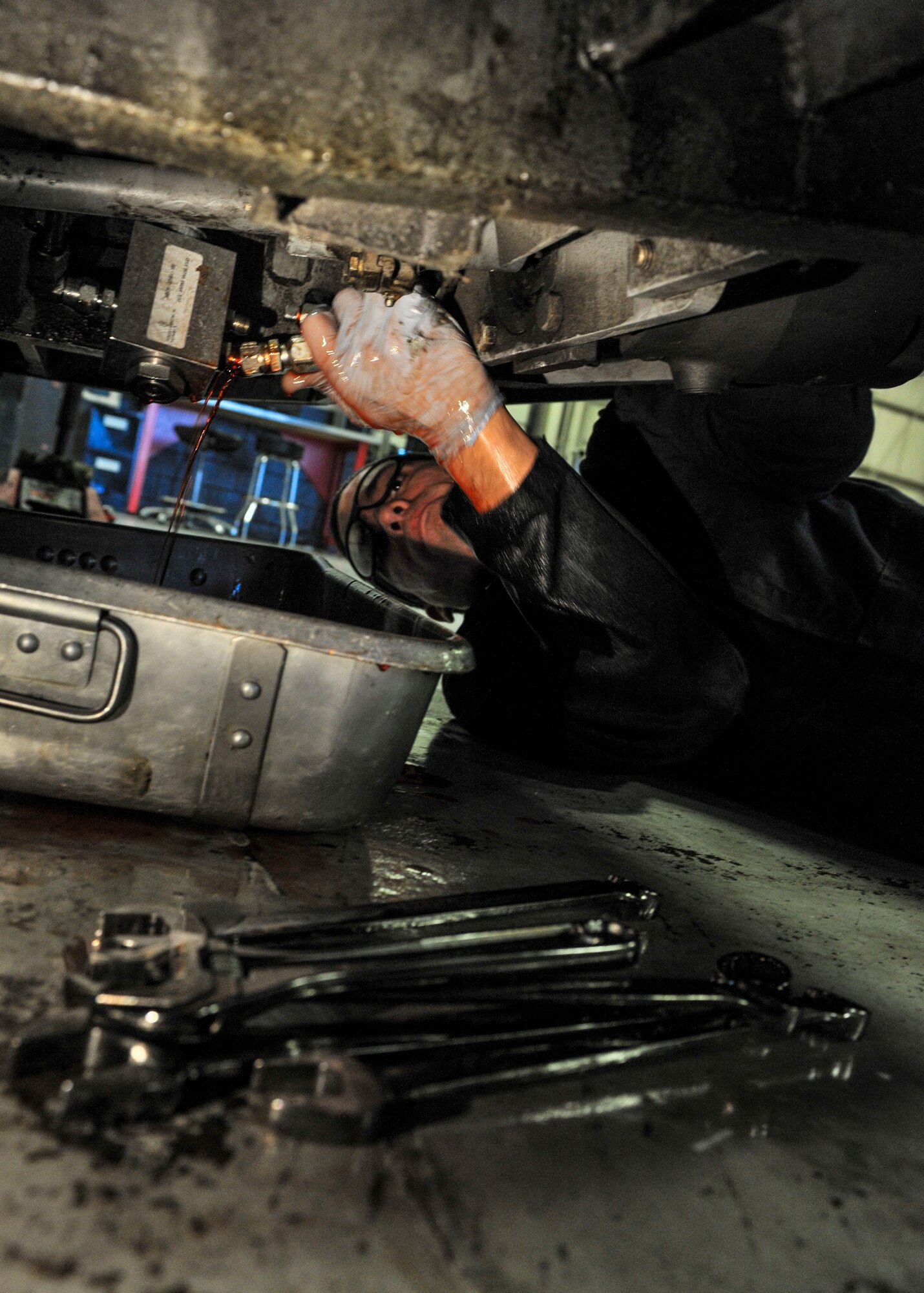 Senior Airman Michael Maldonada, 5th Maintenance Squadron air ground equipment journeyman, drains fluid out of a brake line on Minot Air Force Base, N.D., Nov. 25, 2014. Maldonada removed the brake pedal and drained the brake fluid to repair a minor leak in the line. (U.S. Air Force photo/Senior Airman Stephanie Morris)