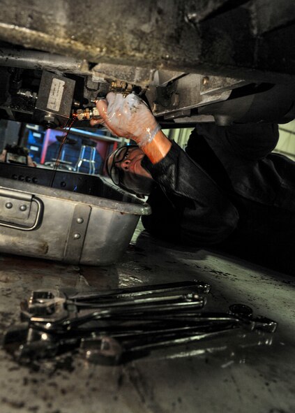Senior Airman Michael Maldonada, 5th Maintenance Squadron air ground equipment journeyman, drains fluid out of a brake line on Minot Air Force Base, N.D., Nov. 25, 2014. Maldonada removed the brake pedal and drained the brake fluid to repair a minor leak in the line. (U.S. Air Force photo/Senior Airman Stephanie Morris)