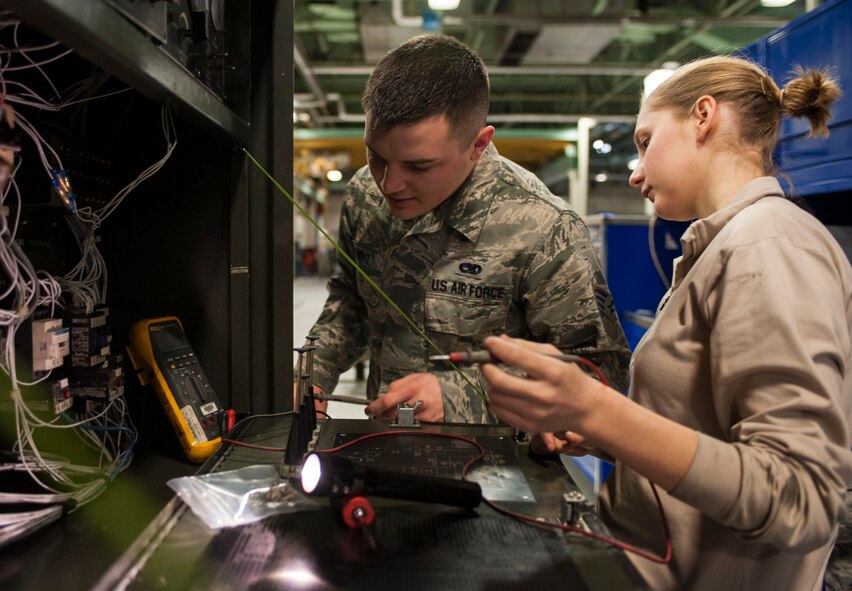 Senior Airman Cody Knight, 5th Maintenance Squadron air ground equipment journeyman, helps Airman 1st Class Mikaela Durose, 5th MXS AGE apprentice; troubleshoot a relay on a MA-3D air conditioner on Minot Air Force Base, N.D., Nov. 25, 2014. The relay unit helps run the air conditioner’s engine and is part of a direct current circuit. (U.S. Air Force photo/Senior Airman Stephanie Morris)