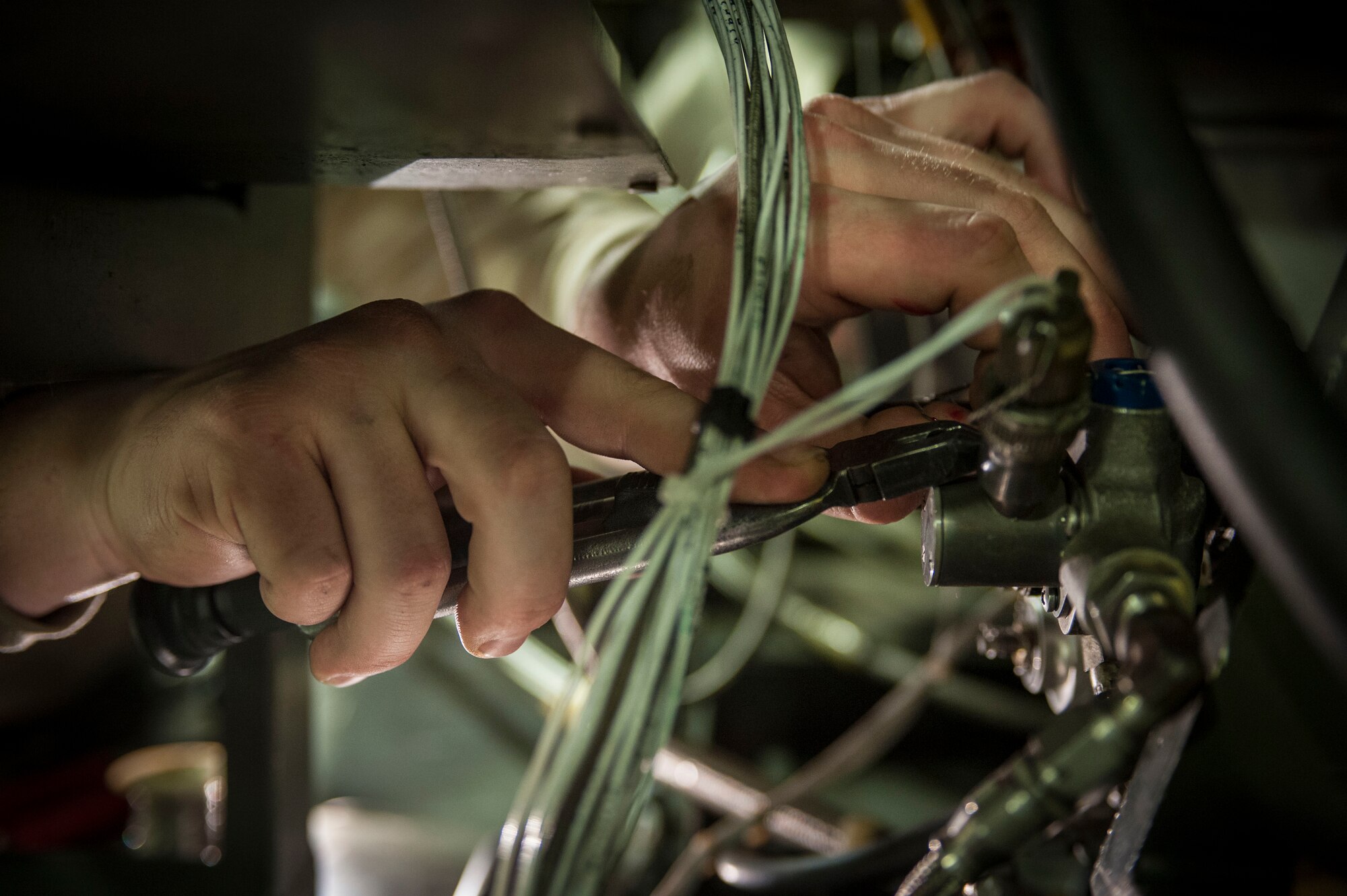 Senior Airman Jacob Jervell, 5th Maintenance Squadron air ground equipment journeyman, affixes safety wire to a cannon plug on a Dash 95 Air Source on Minot Air Force Base, N.D., Nov. 25, 2014. All parts not bolted in place on the air source must be held in place by safety wire. (U.S. Air Force photo/Senior Airman Stephanie Morris)