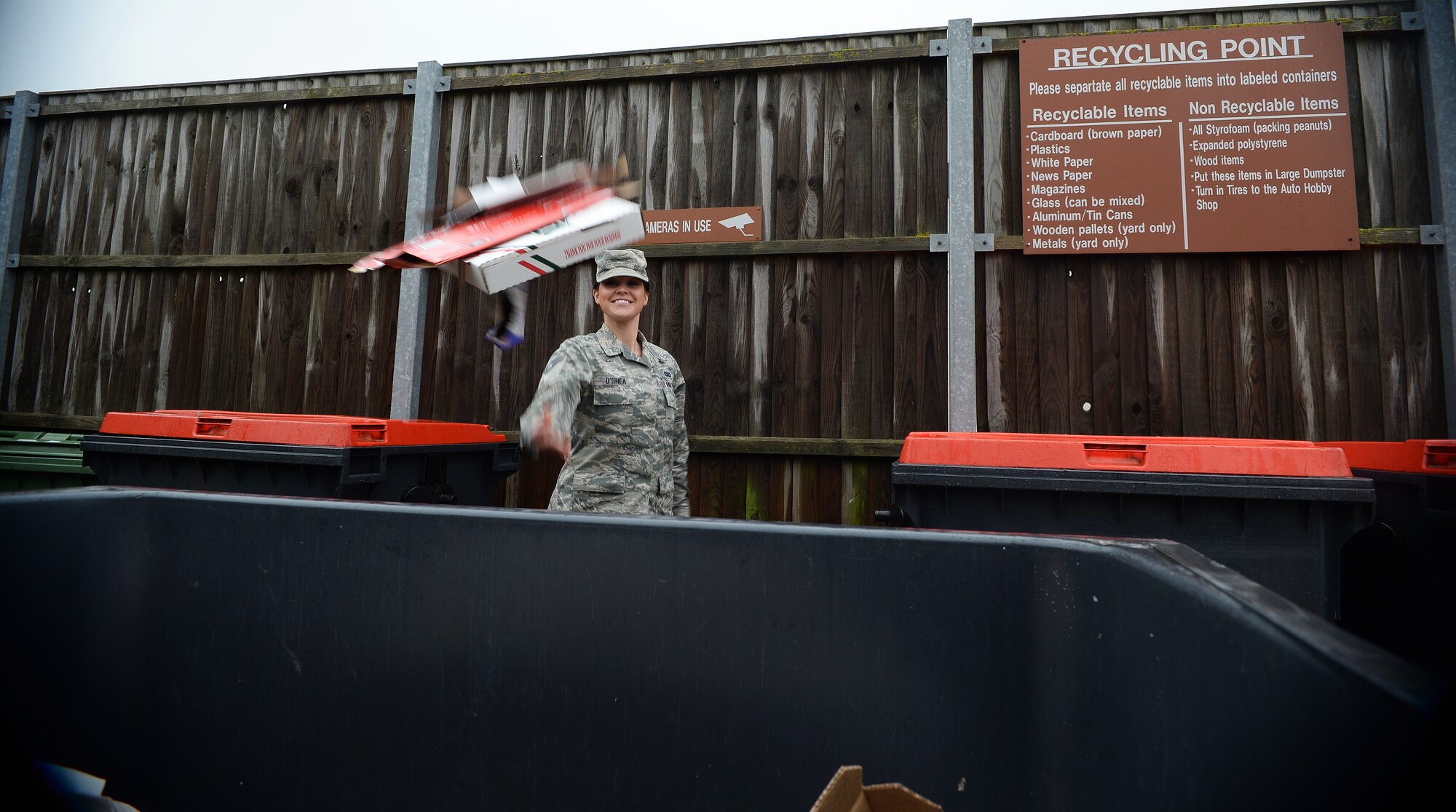 Senior Airman Erin O’Shea, 48th Fighter Wing Public Affairs photojournalist, disposes of cardboard at the recycling center at Royal Air force Lakenheath, England, Nov. 26, 2014. The recycling center collects and recycles a wide variety of items like paper, plastic, textiles, wood, cardboard, paper and metals. (U.S. Air Force photo by Staff Sgt. Emerson Nuñez/Released)
