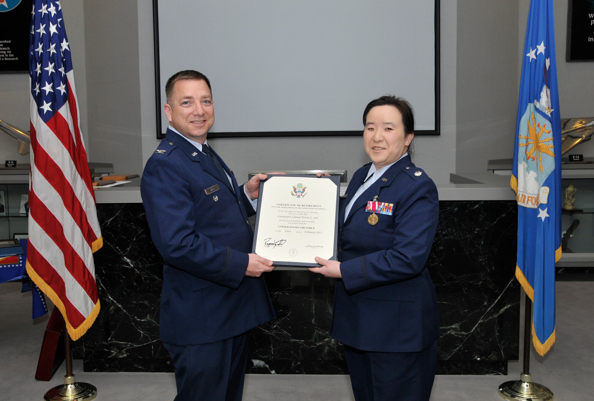 Lt. Col. Teresa Suh (right), formerly the Director of Operations with the AEDC Test Operations Division (TST), accepts a U.S. Air Force Certificate of Retirement from retiring official Col. Timothy West, the AEDC TST director, at a retirement ceremony in her honor on Oct. 31 at AEDC. Suh was assigned to AEDC from May 31, 2012 through Oct. 31, 2014. (Photo by Jacqueline Cowan)