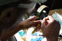 Airman 1st Class Dexter Wilson, 5th Communications Squadron cable and antenna systems maintenance technician, prepares to splice a fiber optic cable to restore internet services to a portion of Minot Air Force Base, N.D., Aug. 27, 2014. The cable and antenna systems maintenance work center is one of the busiest shops within the squadron. (U.S. Air Force photo/Capt. Jeff M. Nagan)
