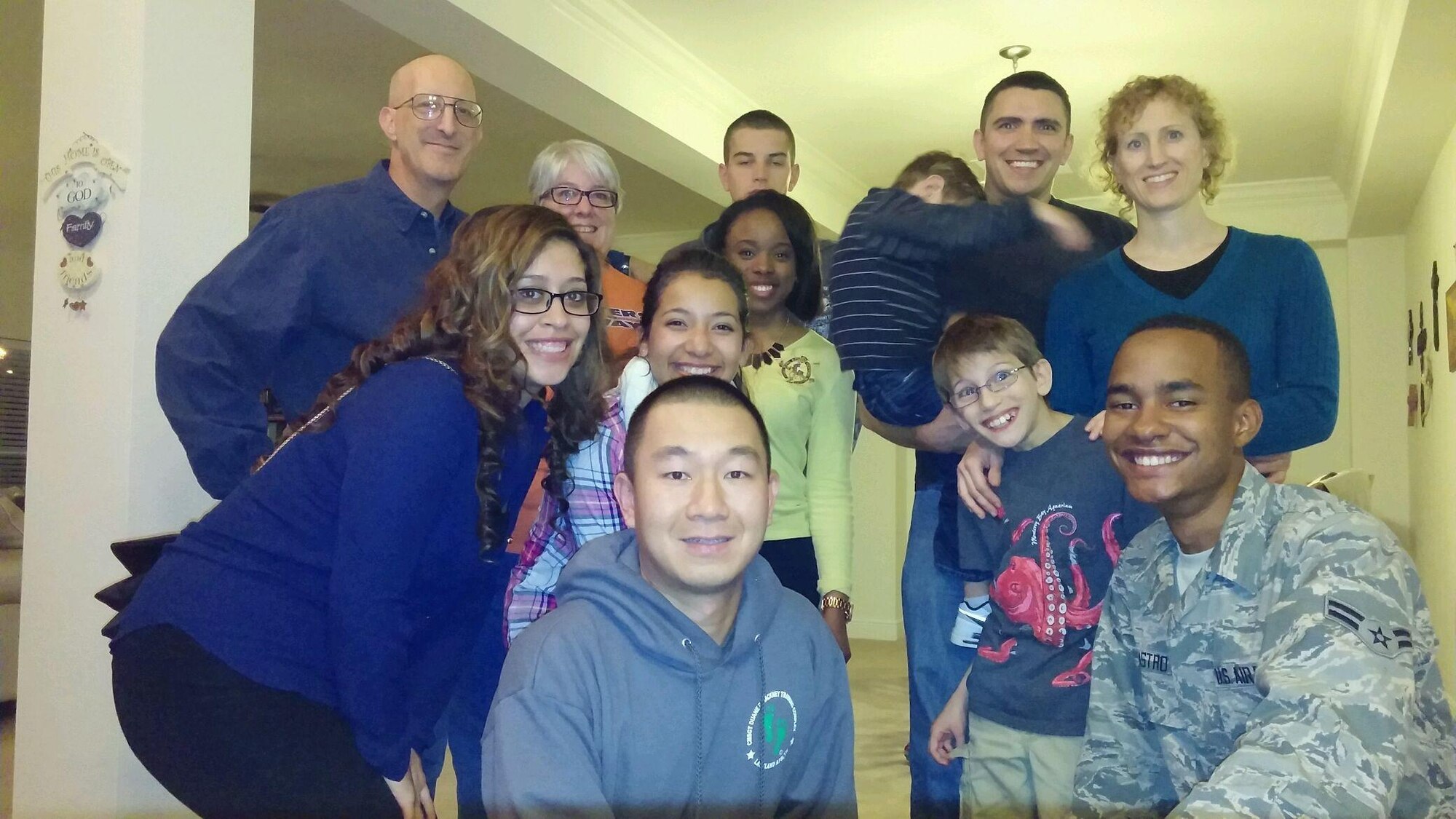 Keesler Airmen pose for a photo during a Thanksgiving meal at Chaplain (Col.) David Terrinoni’s house Nov. 27, 2014. Terrinoni and his wife sponsored seven Airmen and two officers and their spouses from the 81st Training Group for the Home Away From Home program. A base tradition for 18 years, the program allows the Keesler community of active duty, retired and civil service personnel to host non-prior service Airmen in their homes to celebrate Thanksgiving Day. (Courtesy Photo)