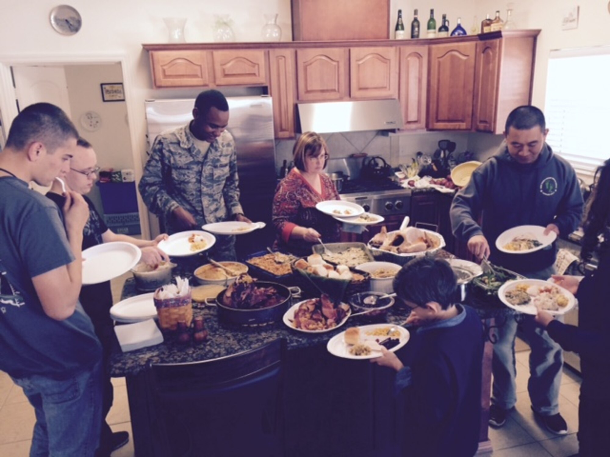 Keesler Airmen fill their plates during a Thanksgiving meal at Chaplain (Col.) David Terrinoni’s house Nov. 27, 2014. Terrinoni and his wife sponsored seven Airmen and two officers and their spouses from the 81st Training Group for the Home Away From Home program. A base tradition for 18 years, the program allows the Keesler community of active duty, retired and civil service personnel to host non-prior service Airmen in their homes to celebrate Thanksgiving Day. (Courtesy Photo)