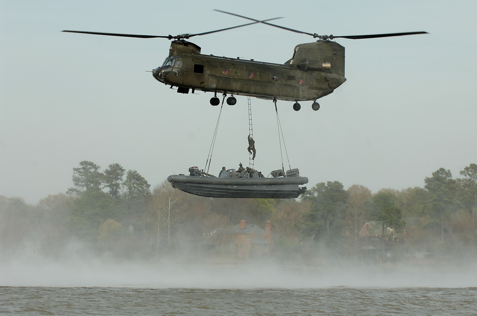 A U.S. Navy Special Boat Team 20 Sailor climbs a ladder into a U.S. Army 5-159th General Support Aviation Battalion CH-47 Chinook during a training exercise at Fort Eustis, Va., April 11, 2014. The training increased the range of effectiveness for naval assets by utilizing aviation units to carry special warfare teams and their watercraft from one point to another.  (U.S. Air Force photo by Senior Airman Teresa J.C. Aber/Released) 
