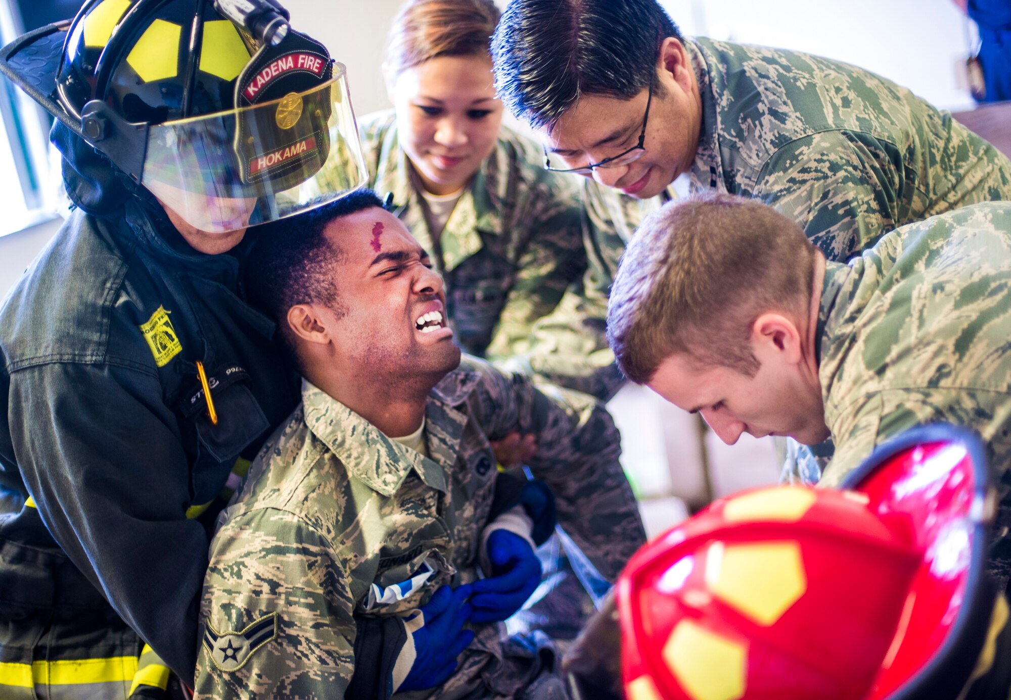 U.S. Air Force emergency responders treat a simulated active shooter victim as part of a mission focused exercise on Kadena Air Base, Japan, Dec. 1, 2014. The scenario was implemented to test Kadena's emergency responders on tactics and procedures in order to prepare them for potential real-world situations. (U.S. Air Force photo by Senior Airman Tyler Prince/Released) 