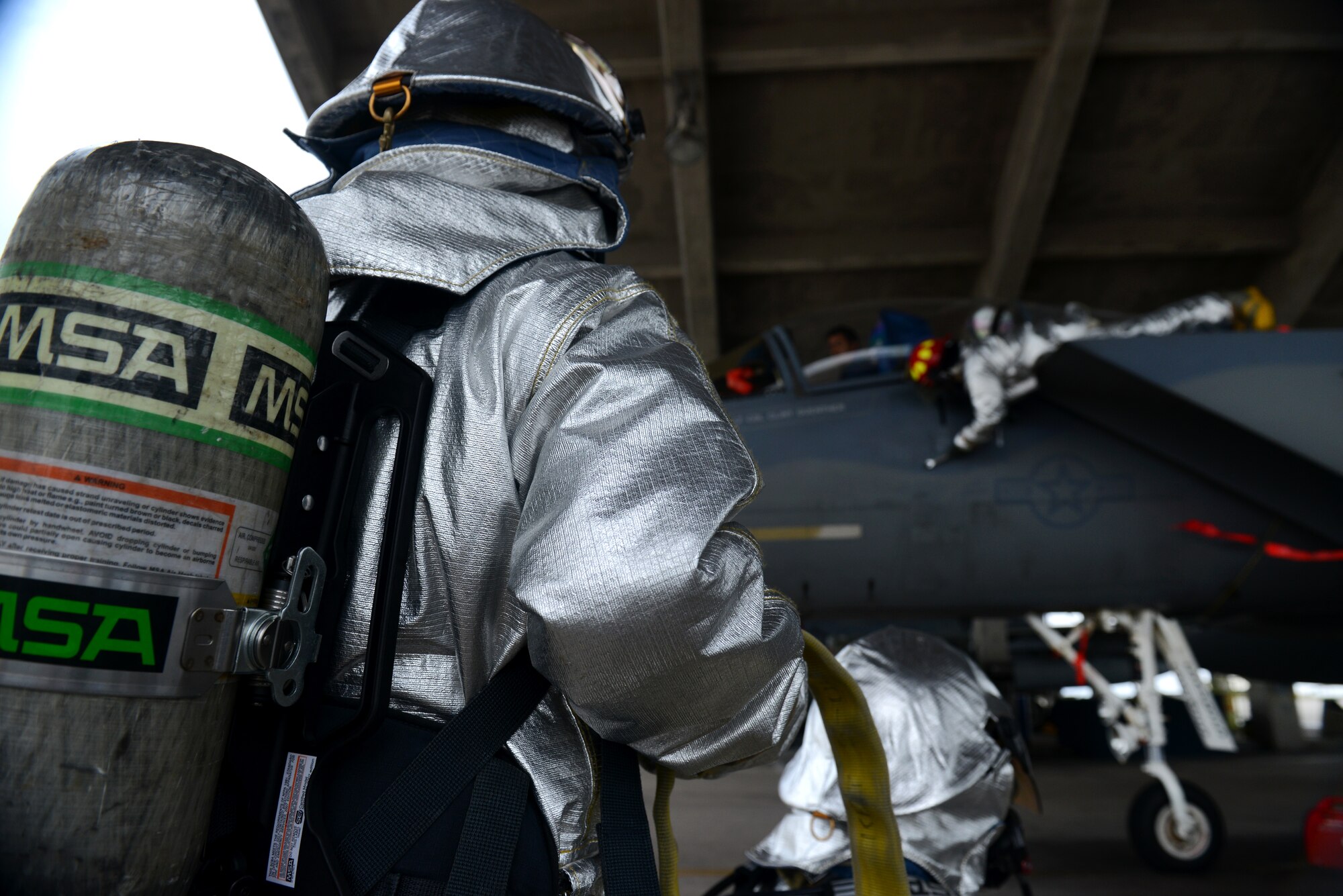 U.S. Air Force firefighters from the 18th Civil Engineer Squadron work to rescue a victim caught in the cockpit of an F-15C Eagle during a simulated aircraft fire as part of a mission focused exercise on Kadena Air Base, Japan, Dec. 1, 2014. MFEs test Airmen on their ability to respond to emergency situations in order to better prepare them for future real-world situations. (U.S. Air Force photo by Senior Airman Maeson L. Elleman/Released) 