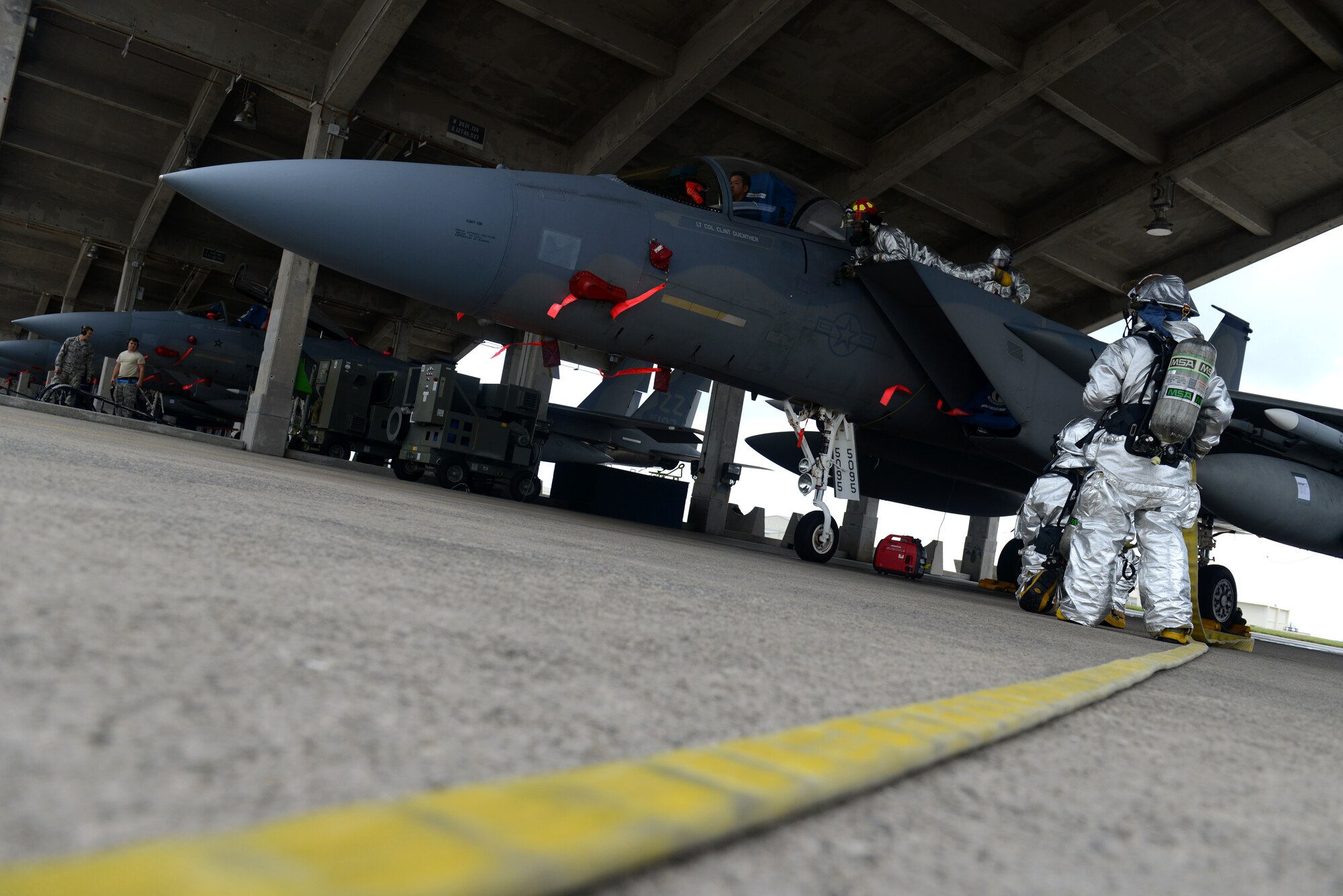 U.S. Air Force firefighters from the 18th Civil Engineer Squadron work to rescue a victim caught in the cockpit of an F-15C Eagle during a simulated aircraft fire as part of a mission focused exercise on Kadena Air Base, Japan, Dec. 1, 2014. Kadena periodically hosts MFEs to train Airmen on a variety of scenarios ranging from active shooters to aircraft mishaps in order to prepare them for potential real-world situations in the future. (U.S. Air Force photo by Senior Airman Maeson L. Elleman/Released) 