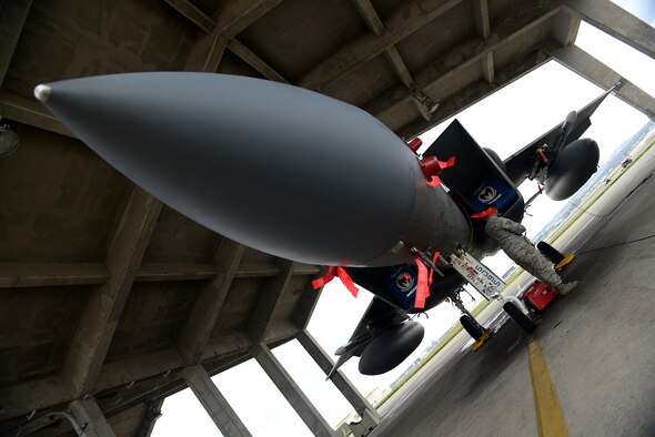 A U.S. Air Force wing inspection team member installs a smoke machine on an F-15C Eagle to simulate aircraft fire as part of a mission focused exercise on Kadena Air Base, Japan, Dec. 1, 2014. WIT members use a variety of different tools and scenarios to test Airmen's ability to respond quickly, safely and effectively to a range of situations ranging from aircraft incidents to chemical attacks. (U.S. Air Force photo by Senior Airman Maeson L. Elleman/Released) 