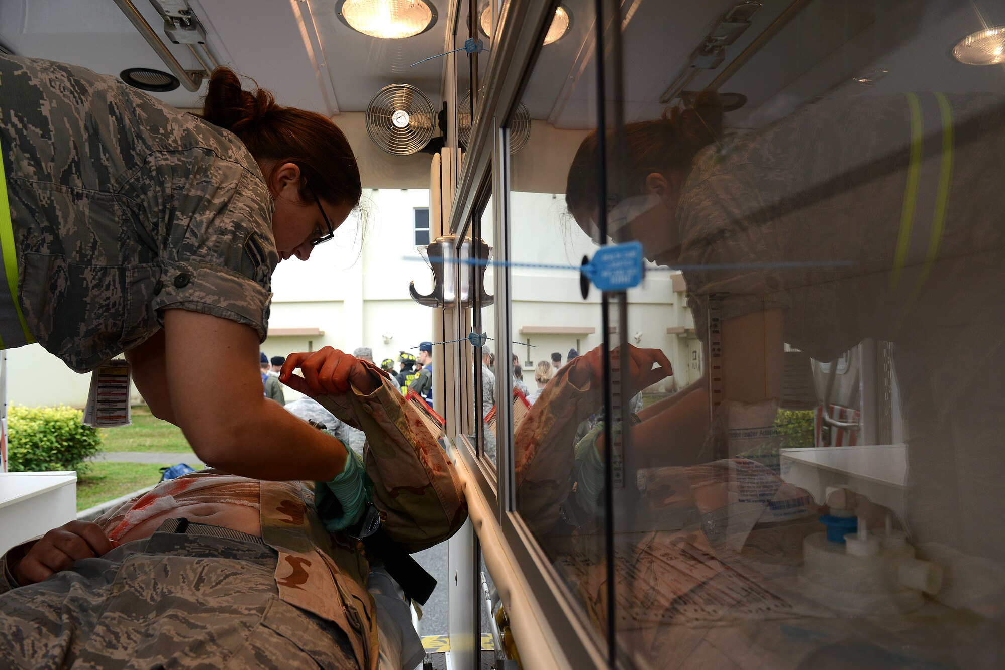 U.S. Air Force Airman 1st Class Joanna Rankin fastens Airman Arthur Steinbrecher, a victim during a simulated active shooter exercise, into a gurney in the back of an ambulance during the exercise on Kadena Air Base, Japan, Dec. 1, 2014. The scenario was implemented as part of a mission focused exercise, which is slated to run through Dec. 4. During the exercise, Airmen will be tested on a variety of scenarios ranging from self-aid and buddy care to chemical attacks. Steinbrecher is a 18th Logistics Readiness Squadron vehicle operator, and Rankin is an 18th Aerospace Medicine Squadron aerospace medicine technician. (U.S. Air Force photo by Senior Airman Maeson L. Elleman/Released) 
