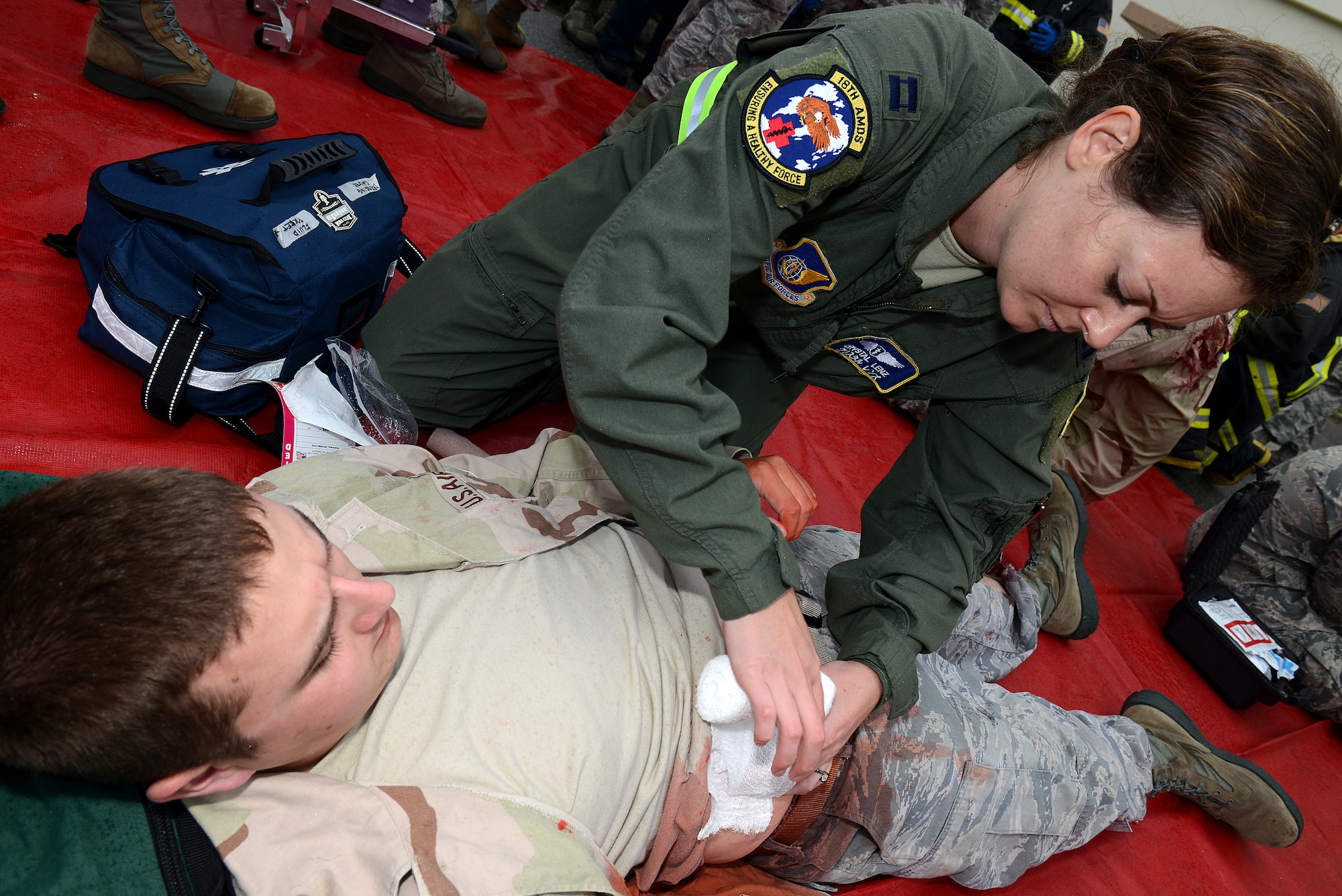 U.S. Air Force Capt. Crystal Lenz, 18th Aerospace Medicine Squadron flight surgeon, treats a victim during an active shooter scenario on Kadena Air Base, Japan, Dec. 1, 2014. The scenario was implemented to test Kadena's emergency responders on tactics and procedures in order to prepare them for potential real-world situations. (U.S. Air Force photo by Senior Airman Maeson L. Elleman/Released)
