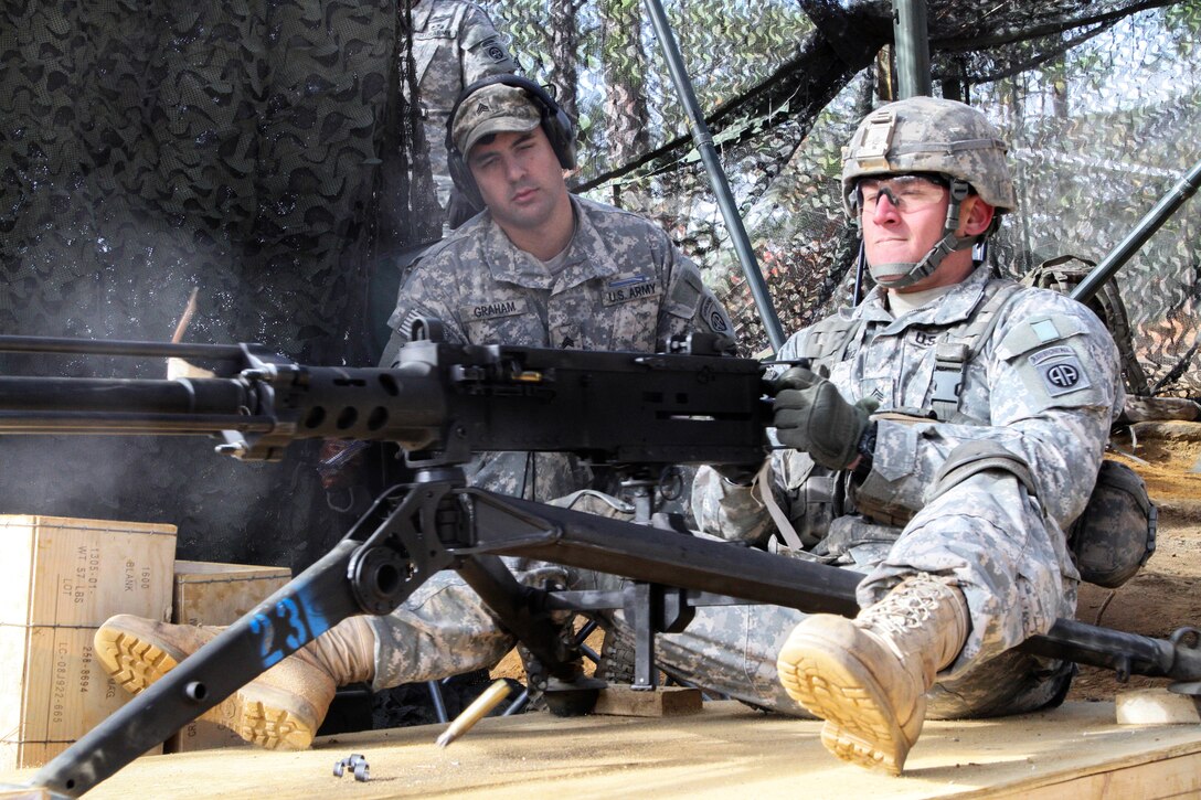 Army Sgt. Robert A. Ruiz, right, demonstrates proper function of the M2 machine gun during Expert Infantry Badge testing on Fort Bragg, N.C., Nov. 18, 2014. Ruiz is an infantryman assigned to the 82nd Airborne Division's 2nd Battalion, 508th Parachute Infantry Regiment, 2nd Brigade Combat Team.