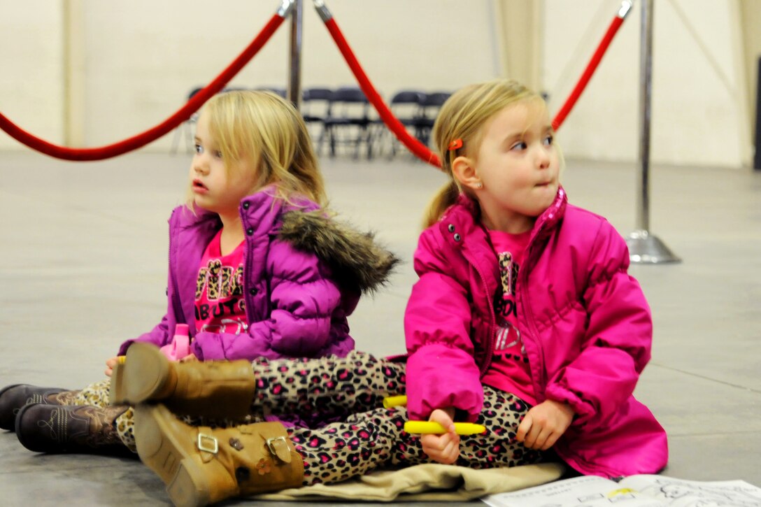 Aubrey and Sarah Basso anxiously await the return of their dad, Army Chief Warrant Officer 2 Ryan Basso from Afghanistan in the early morning hours on Fort Bragg, N.C., Nov. 28, 2014. Basso is assigned to the 82nd Airborne Division's Combat Aviation Brigade.