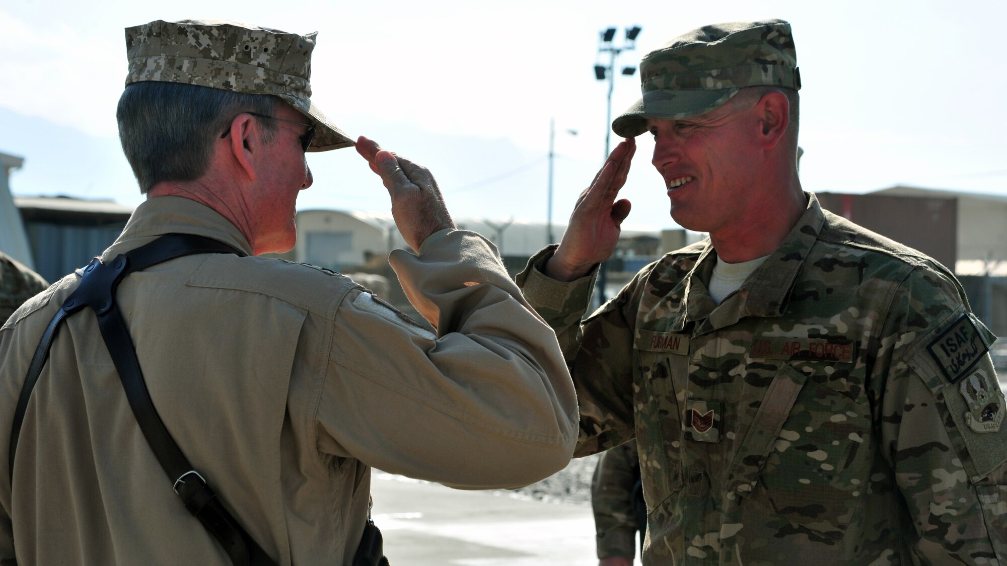 U.S. Air Force Tech. Sgt. Frank Furman, 455th Expeditionary Civil Engineer Squadron and U.S. Air Force Gen. Hawk Carlisle, commander of Air Combat Command, exchange salutes during an orientation visit Nov. 27, 2014 at Bagram Airfield, Afghanistan. Furman, on his ninth deployment, briefed the general about 455 ECES equipment and practices. (U.S. Air Force photo by Staff Sgt. Whitney Amstutz/released)