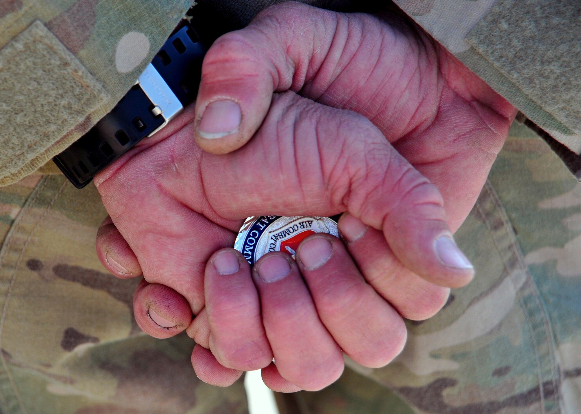 U.S. Air Force Tech. Sgt. Frank Furman, 455th Expeditionary Civil Engineer Squadron, clutches an Air Combat Command commander coin Nov. 27, 2014 at Bagram Airfield, Afghanistan. The coin was presented to Furman by U.S. Air Force Gen. Hawk Carlisle, commander of ACC, for his excellence in communicating the importance of the 455 ECES mission. (U.S. Air Force photo by Staff Sgt. Whitney Amstutz/released)