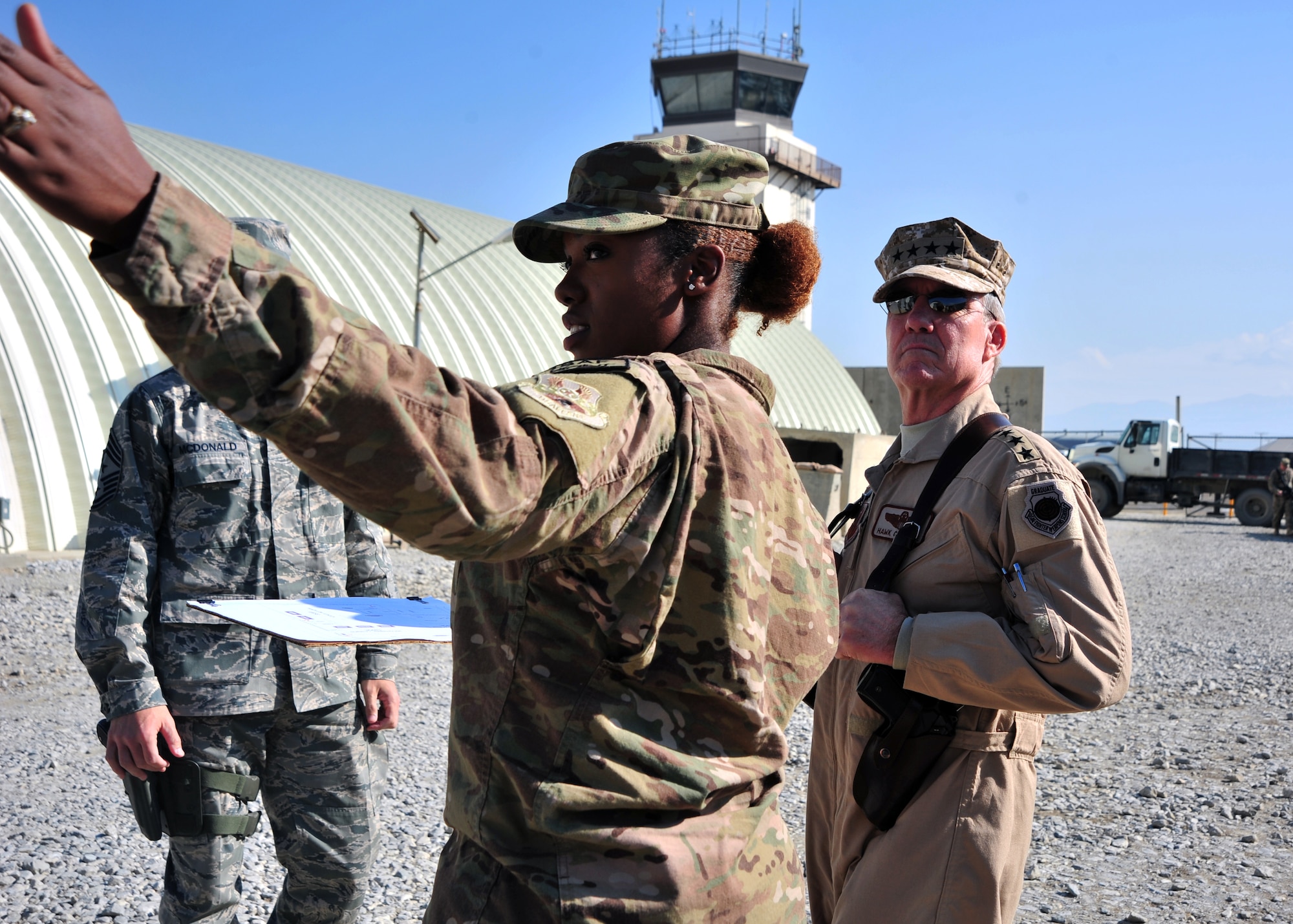 Senior Airman Amber Urbano, 455th Expeditionary Communications Squadron, directs the attention of U.S. Air Force Gen. Hawk Carlisle, commander of Air Combat Command, to a combat lockdown and defense demonstration Nov. 27, 2014 at Bagram Airfield, Afghanistan. The demonstration allowed Carlisle to gauge the response time and preparedness of Airmen assigned to the 455 ECS. (U.S. Air Force photo by Staff Sgt. Whitney Amstutz/ released)