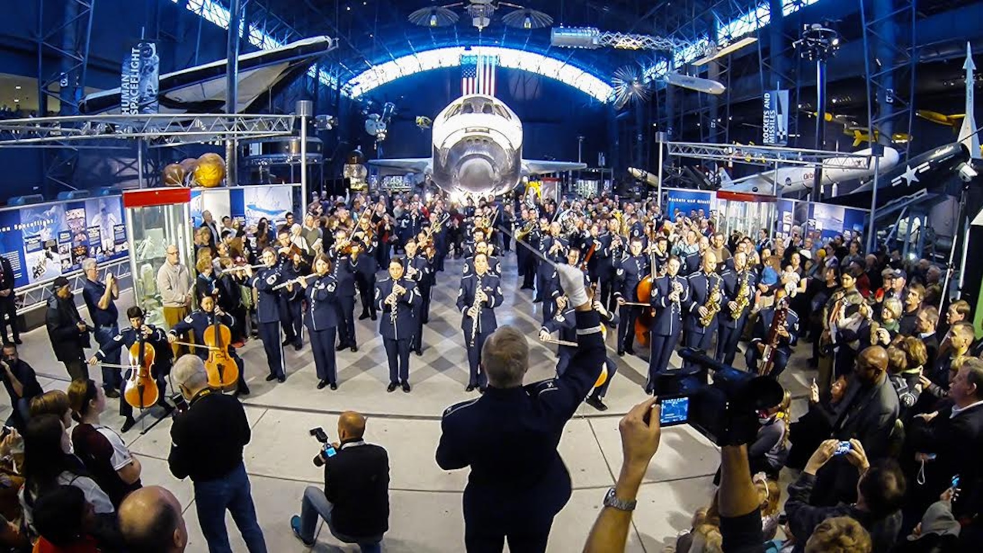 The United States Air Force Band performs a holiday flash mob Dec. 2, 2014, at the Smithsonian National Air and Space Museum Udvar-Hazy Center in Chantilly, Va. The band’s mission is to honor those who have served, inspire American citizens to heightened patriotism and service, and positively impact the global community on behalf of the U.S. Air Force and America. (U.S. Air Force photo/Staff Sgt. Devon Suits)