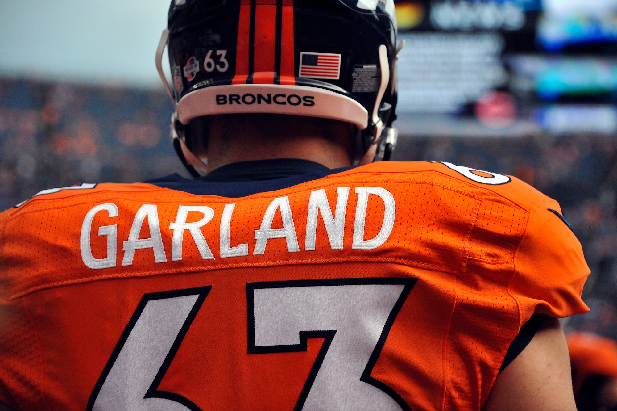 Then-1st Lt. Benjamin Garland (63) performs warm up drills Aug 24, 2013, at Sports Authority Field at Mile High Stadium before a game in Denver, Colo. Garland, who originally entered the National Football League in 2010 after graduating from the U.S. Air Force Academy, was on the Bronco’s reserve/military list while fulfilling his active duty obligations in the Air Force. In 2012 Garland joined the Colorado Air National Guard and made the Broncos practice squad as a defensive lineman and is competing this season to make the 53-man final roster. Garland is a Denver Broncos Offensive Guard and 140th Wing public affairs officer. (Air National Guard photo/Tech. Sgt. Wolfram M. Stumpf)