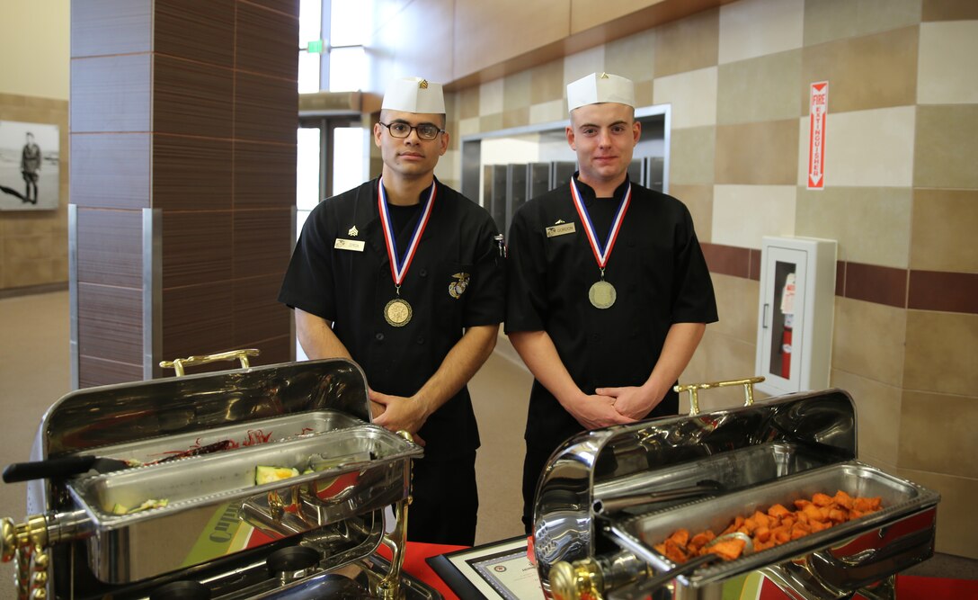Sgt. Hugo P. Zepeda and Lance Cpl. Justin Gordon, food service specialists with Headquarters Squadron, Marine Corps Air Station Yuma, pose for a photograph after taking first place honors at the MCI-West Chef of the Quarter culinary competition here, Dec. 3.  The two were awarded medals and priority seats for a two-month course at the Culinary Institute of America