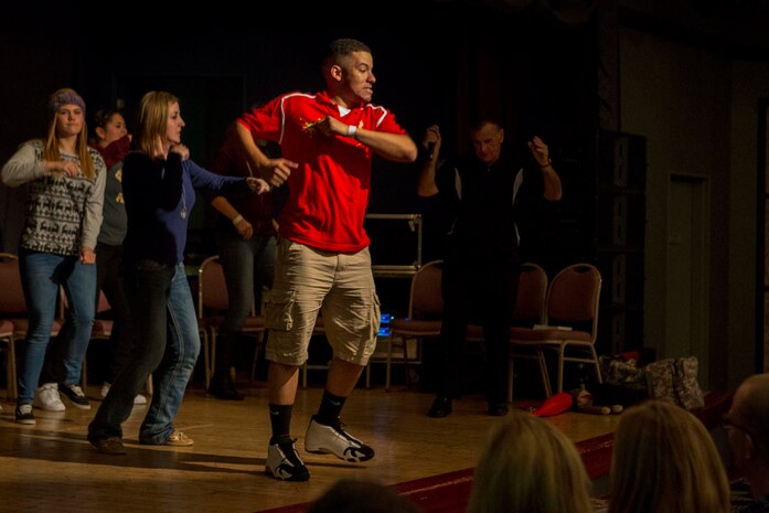 Cpl. Jonathan Lucas, a traffic management specialist with Headquarters and Headquarters Squadron, dances on stage during Chuck Milligan’s comedy hypnotist show inside the Club Iwakuni ballroom aboard Marine Corps Air Station Iwakuni, Japan, Dec. 1, 2014. Marine Corps Community Services invited Milligan back to MCAS Iwakuni to perform his popular hypnotism show for the 10th consecutive year.