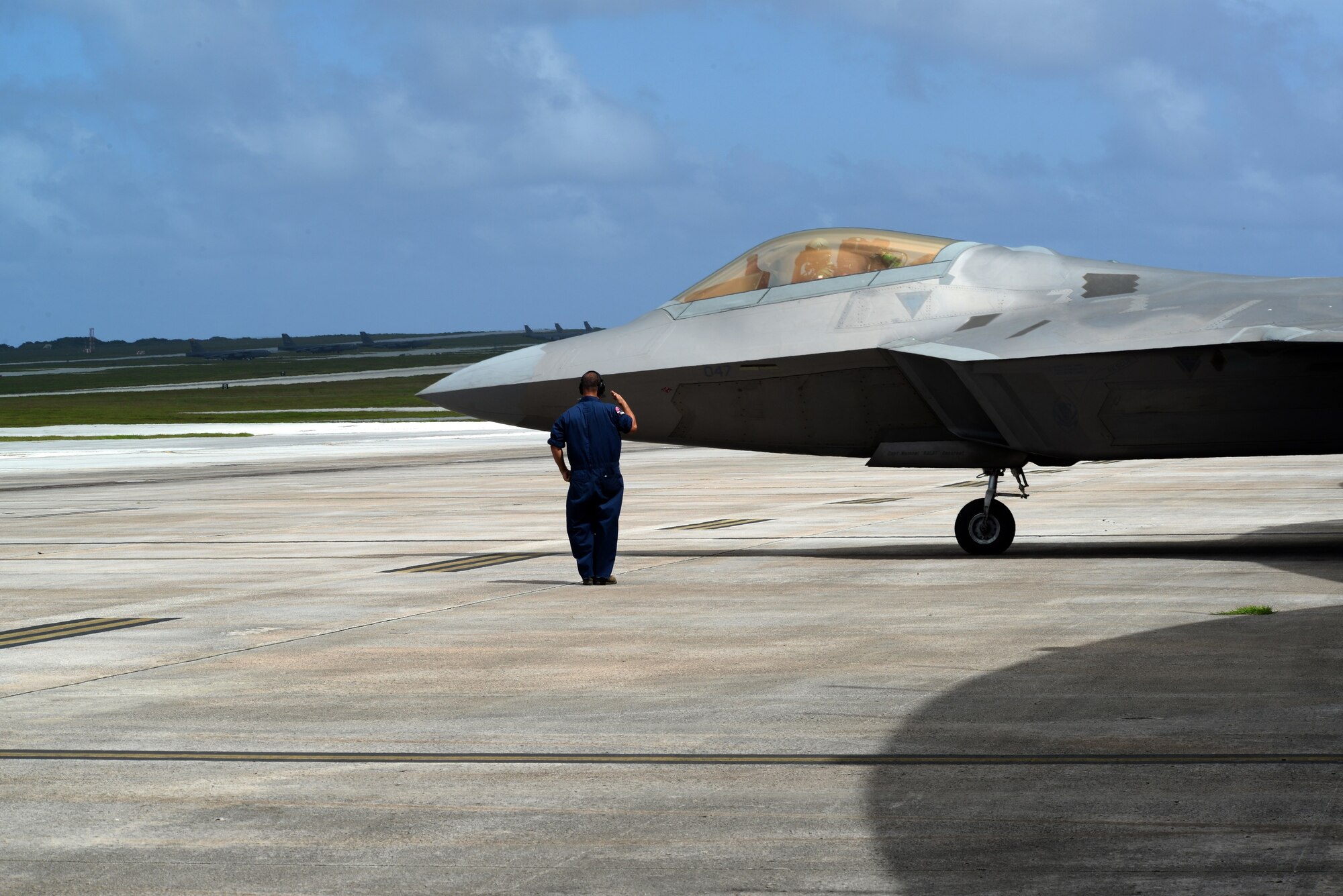 Master Sgt. Shawn Pangborn, 154th Aircraft Maintenance Squadron F-22 Raptor crew chief from Joint Base Pearl Harbor-Hickam, Hawaii salutes as an F-22 departs the hangar Nov. 23, 2014, at Andersen Air Force Base, Guam. A C-17 Globemaster III along with several F-22s operated from Andersen to practice flexibility in aircraft movement at a non-traditional base with additional pilots, maintenance support and accompanying fuel and munitions. (U.S. Air Force photo by Airman 1st Class Amanda Morris/Released)