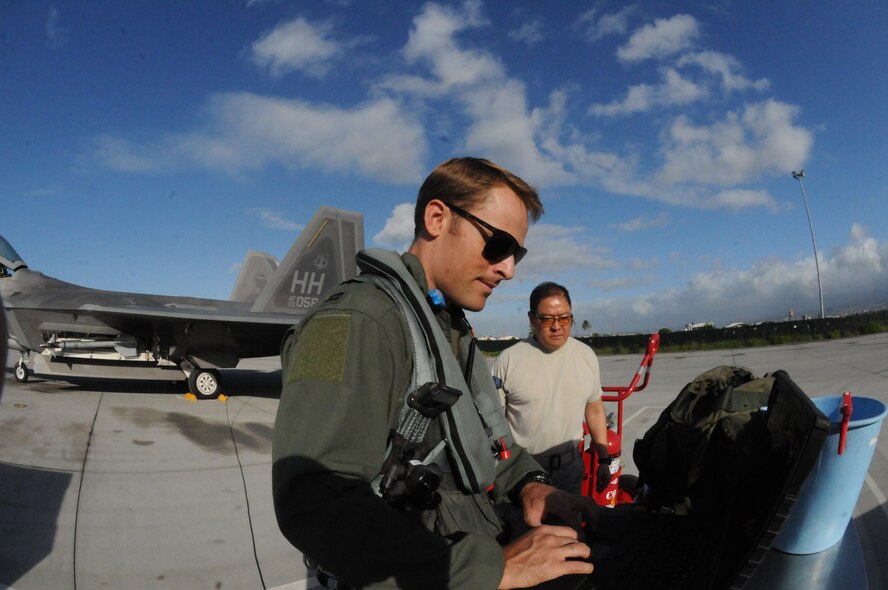 Capt. Austin McIntosh,19th Fighter Squadron F-22 pilot, and Tech. Sgt. Jay Nishimura, 154th Aircraft Maintenance Squadron Avionic Systems specialist, review aircraft forms  prior to taking-off from Joint Base Pearl Harbor Hickam, Hawaii Nov. 20. Airmen from the 15th and 154th Wings exercised the Rapid Raptor concept, the newest approach to fighter employment, which uses at least one C-17 to swiftly move, refuel and rearm a minimum of four F-22s in unfamiliar environments.(Hawaii Air National Guard photo/Senior Airman Orlando Corpuz)