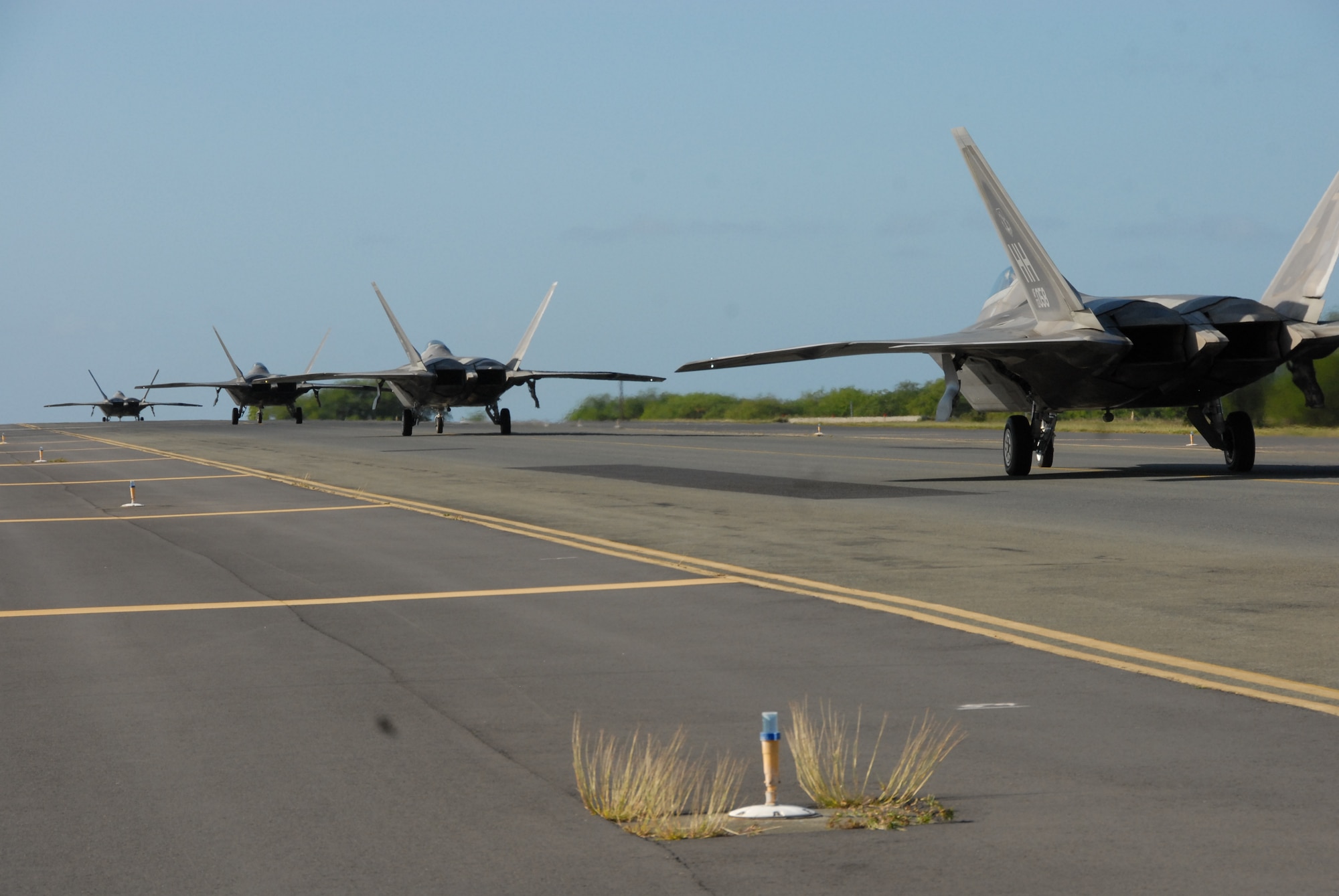Four F-22 Raptors from the 19th and 199th Fighter Squadrons taxi prior to take-off Nov. 20 at Joint Base Pearl Harbor-Hickam, Hawaii. The Raptors executed a Rapid Raptor deployment, which is still in the proof-of-concept phase, to Andersen, AFB, Guam Nov. 20-24. Once the Rapid Raptor concept becomes an operational capability these small detachments of U.S. fighters performing short-duration deployments aim to strengthen the overall U.S. posture with a smaller footprint than traditional expeditionary forces or theater security packages. (Hawaii Air National Guard photo/Senior Airman Orlando Corpuz)