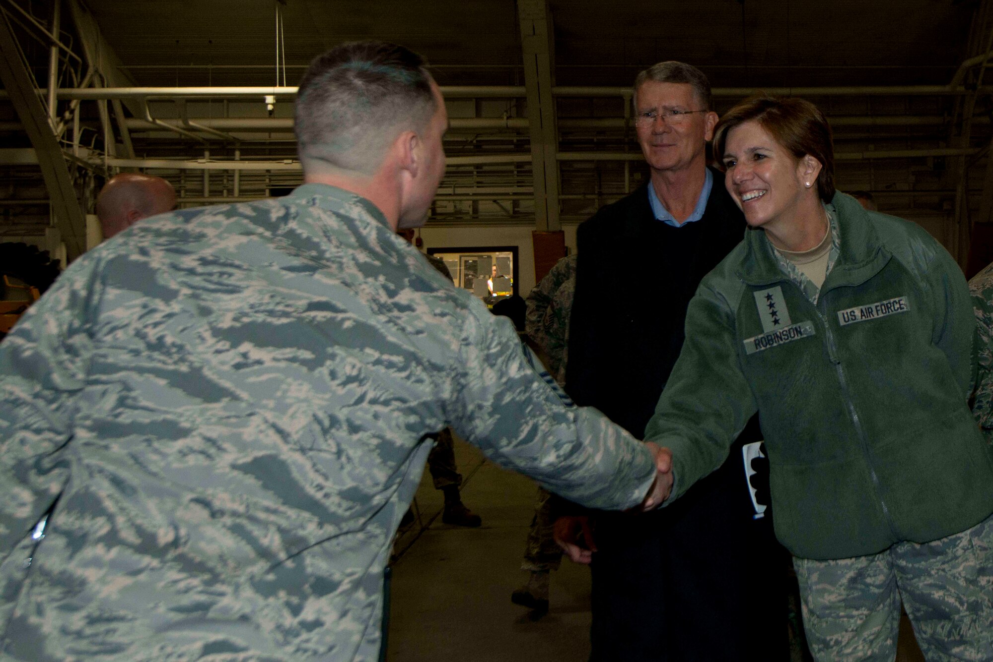 Air Force Gen. Lori Robinson, Pacific Air Forces commander, shakes hands with Senior Master Sgt. Arthur Wholly, 673rd Civil Engineer Squadron deputy fire chief, during her visit at Joint Base Elmendorf-Richardson, Alaska, Dec. 2, 2014. General Robinson visited Airmen and families and witnessed JBER missions and operations during a trip to the base with Chief Master Sgt. Harold Hutchison, PACAF command chief. (U.S. Air Force photo/Staff Sgt. Sheila deVera/RELEASED)