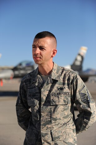 Master Sgt. Shane Sneary, an Air Force Repair Enhancement Program manager with the 57th Maintenance Group, answers questions during an interview with the 2nd Combat Camera Squadron, on the flightline at Nellis Air Force Base, Nev., Oct. 31, 2014. Sneary was interviewed about his cost saving submission to the Airmen Powered by Innovation program. (U.S. Air Force photo by Airman 1st Class Mikaley Towle)