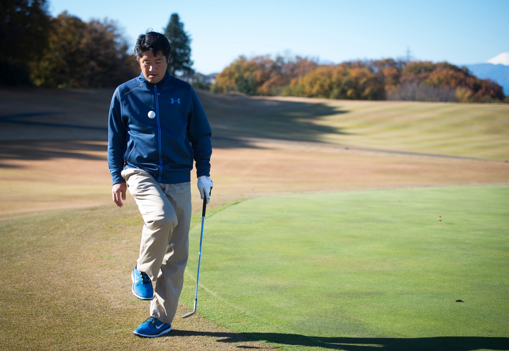 Hiro Fujii, Tama Hills Golf Course assistant director of golf, shows some of his trick shot ability by bouncing a ball off his knee Dec. 2, 2014. Fujii has played golf since he was in junior high school after his father encouraged him to pick up the game. (U.S. Air Force photo by Staff Sgt. Chad C. Strohmeyer)(Released)
