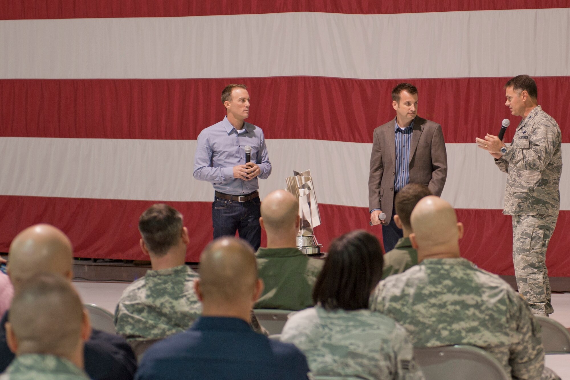Kevin Harvick (left), 2014 NASCAR Sprint Cup champion, and his crew chief, Rodney Childers, speak with Col. Richard Boutwell, 99th Air Base Wing commander, after taking questions from Nellis Airmen during their visit to Nellis Air Force Base, Nev., at the Thunderbirds hangar Dec. 2, 2014. Harvick visited the base on his championship tour to thank service members and meet military fans. (U.S. Air Force photo by Staff Sgt. Victoria Sneed)