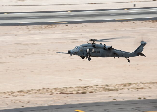 An HH-60 Pave Hawk assigned to the 66th Rescue Squadron practices touch-and-gos near the control tower at Nellis Air Force Base, Nev., Dec. 2, 2014. The control tower is in charge of, and responsible for managing all aircraft operating in Nellis’ airspace. (U.S. Air Force photo by Senior Airman Thomas Spangler)
