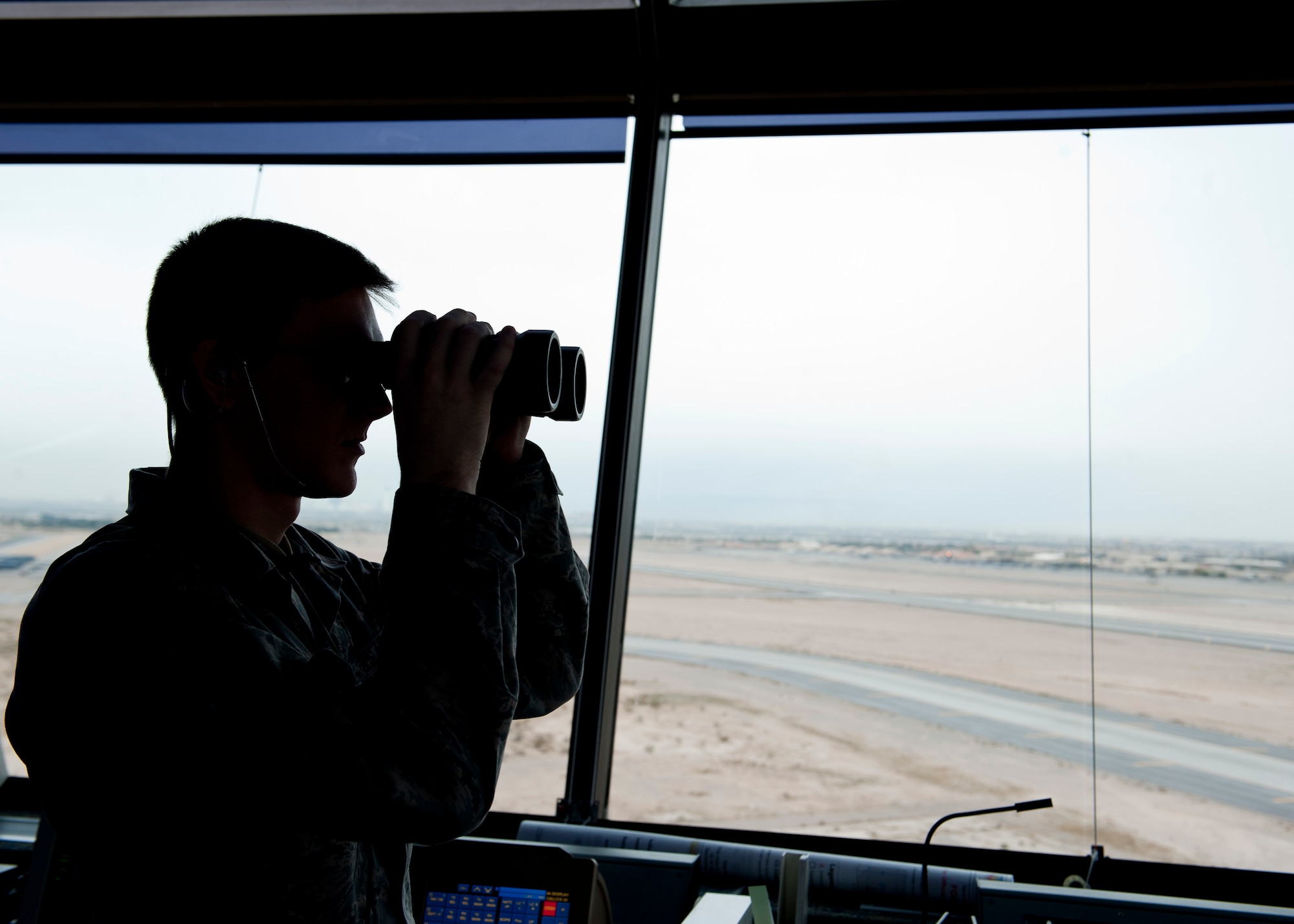 Airman 1st Class Erik Brewer, 57th Operations Support Squadron air traffic controller apprentice, keeps watch over the airfield at Nellis Air Force Base, Nev., Dec. 2, 2014. Every day, the control tower manages approximately 200 aircraft that arrives, departs or flies through Nellis airspace. (U.S Air Force photo by Senior Airman Thomas Spangler)