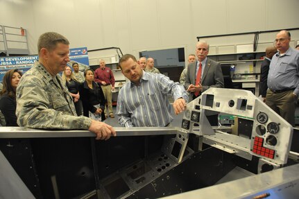 Caleb Schaefer (center), 502nd Trainer Development Squadron, briefs Gen. Robin Rand (left), commander of Air Education and Training Command, Nov. 20 on the T-45 cockpit operations trainer at Joint Base San Antonio-Randolph.  (U.S. Air Force photo by Joel Martinez)

